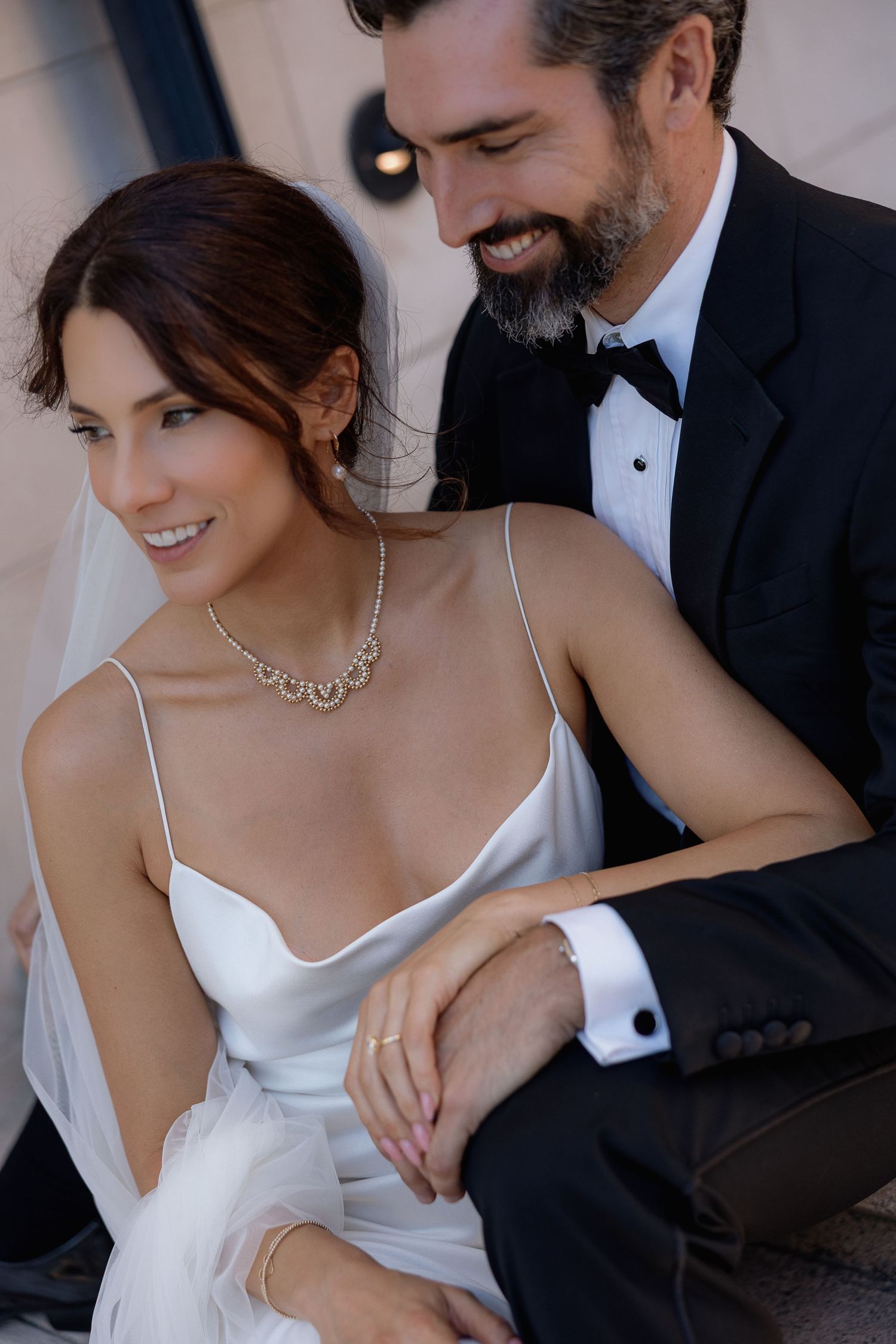 Romantic black and white wedding photo series showing intimate moments between bride in white dress and groom in tuxedo.