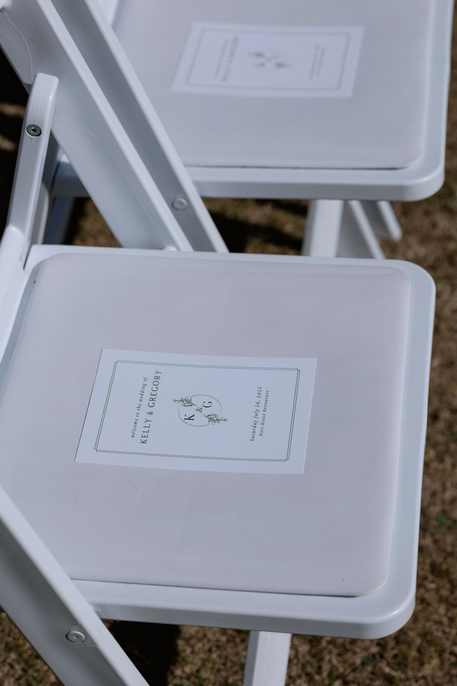 White folding chairs with printed programs set up for a wedding ceremony.