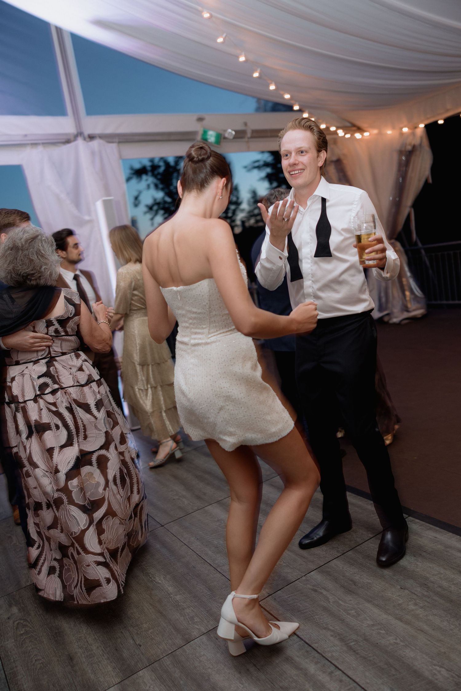 Dancing couple enjoying a moment on the dance floor at a tented wedding reception.