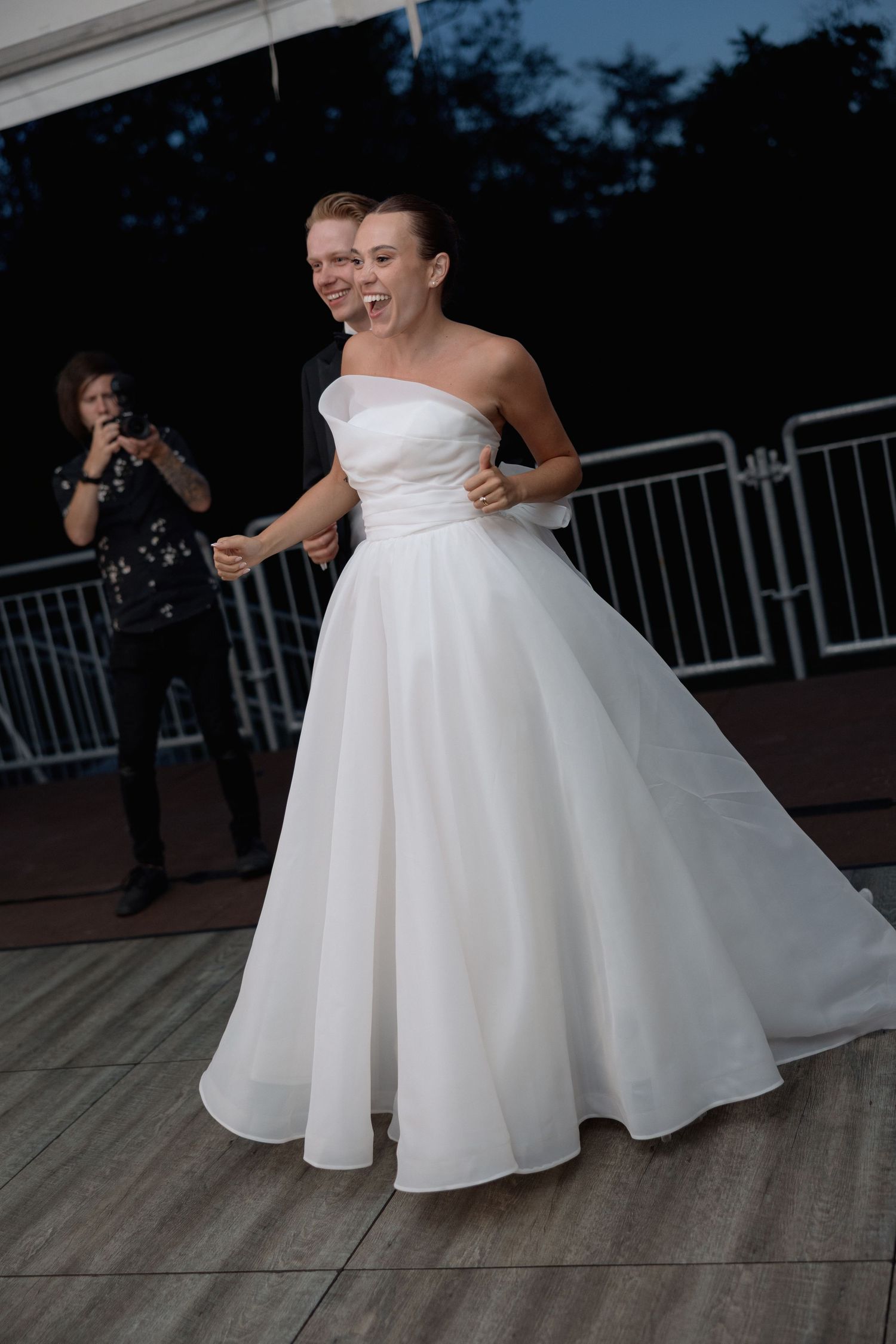 Bride in stunning strapless ballgown twirling on dance floor during wedding reception.