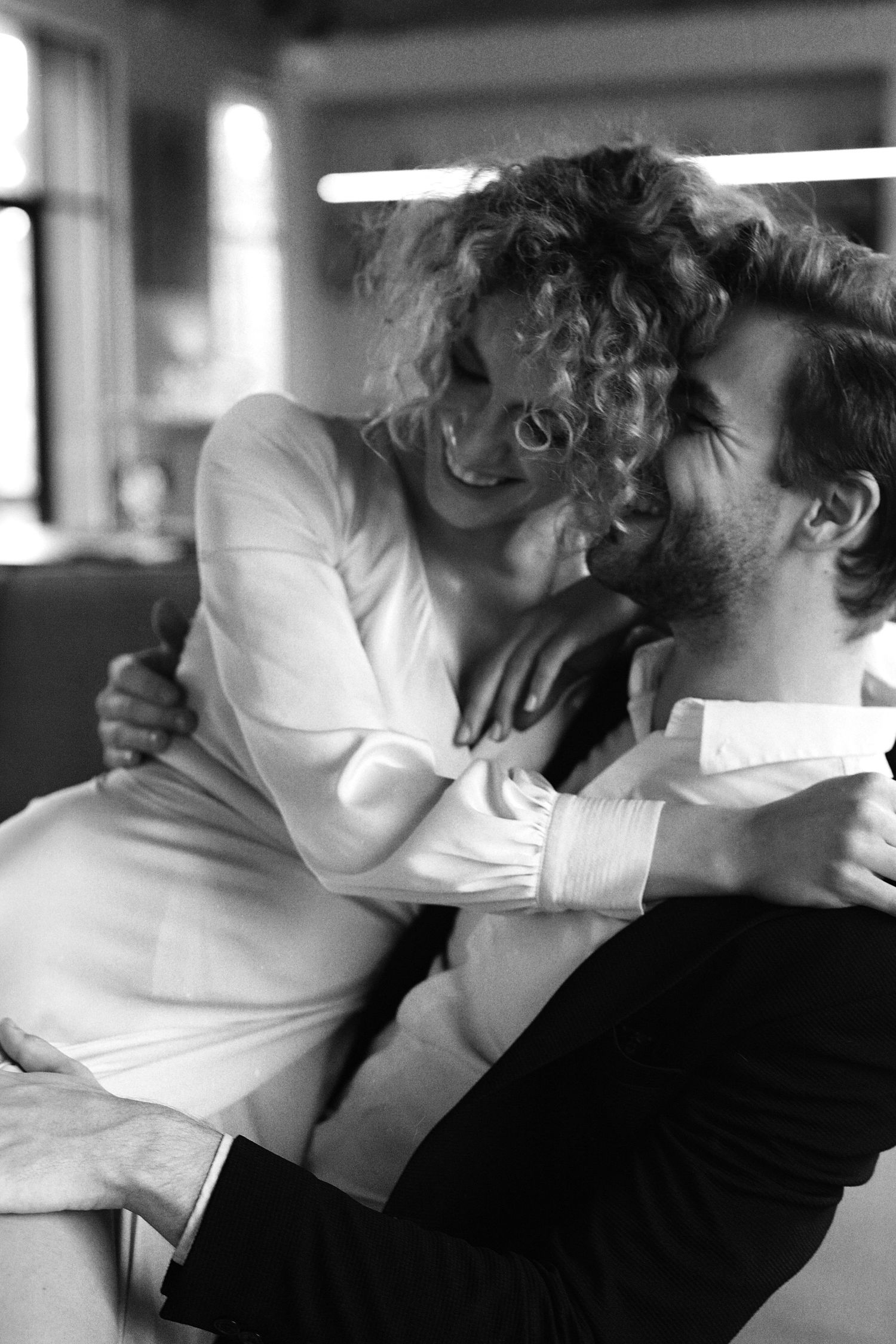 Black and white romantic sequence showing an intimate embrace between two people in white and dark clothing.