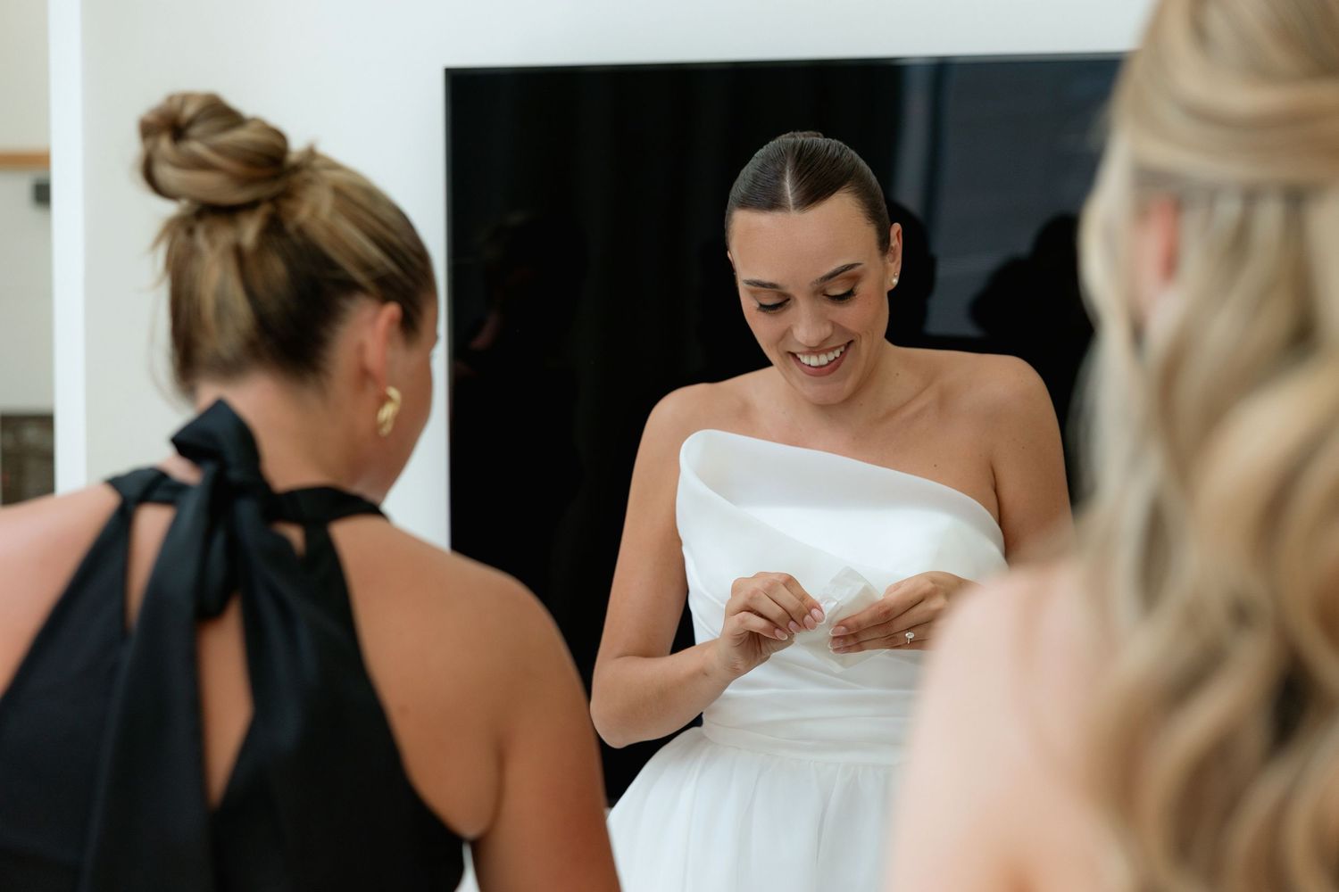 People in formal attire gather closely together during a special event preparation.