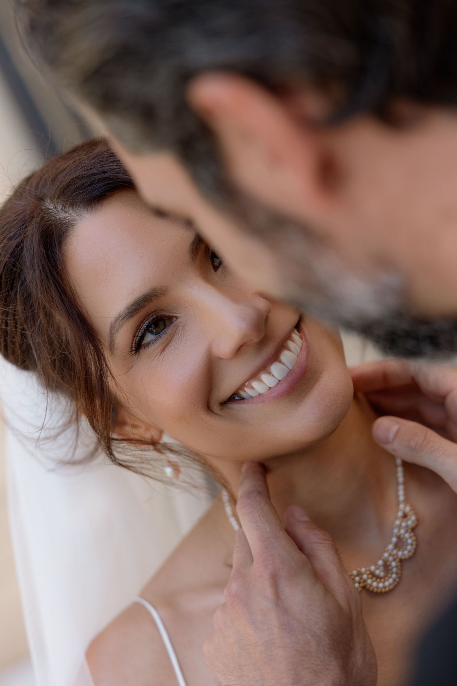 Close up portrait showcasing elegant bridal jewelry and natural makeup.