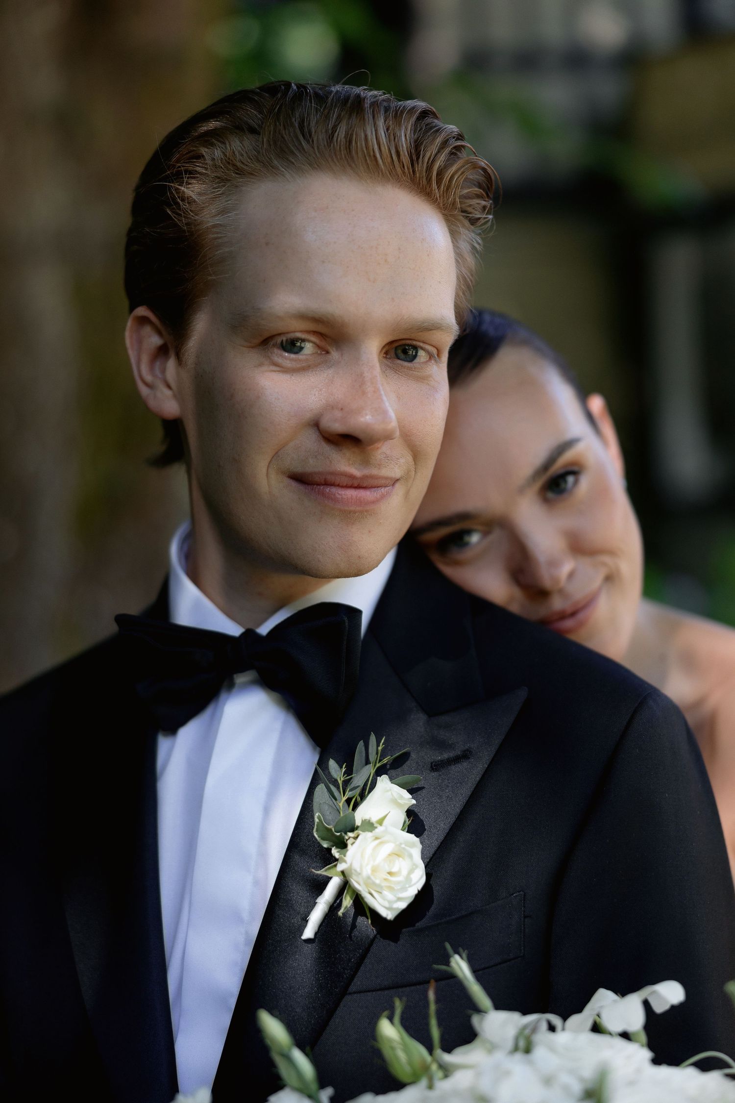 Intimate wedding portrait showing couple's affectionate moment in natural lighting.