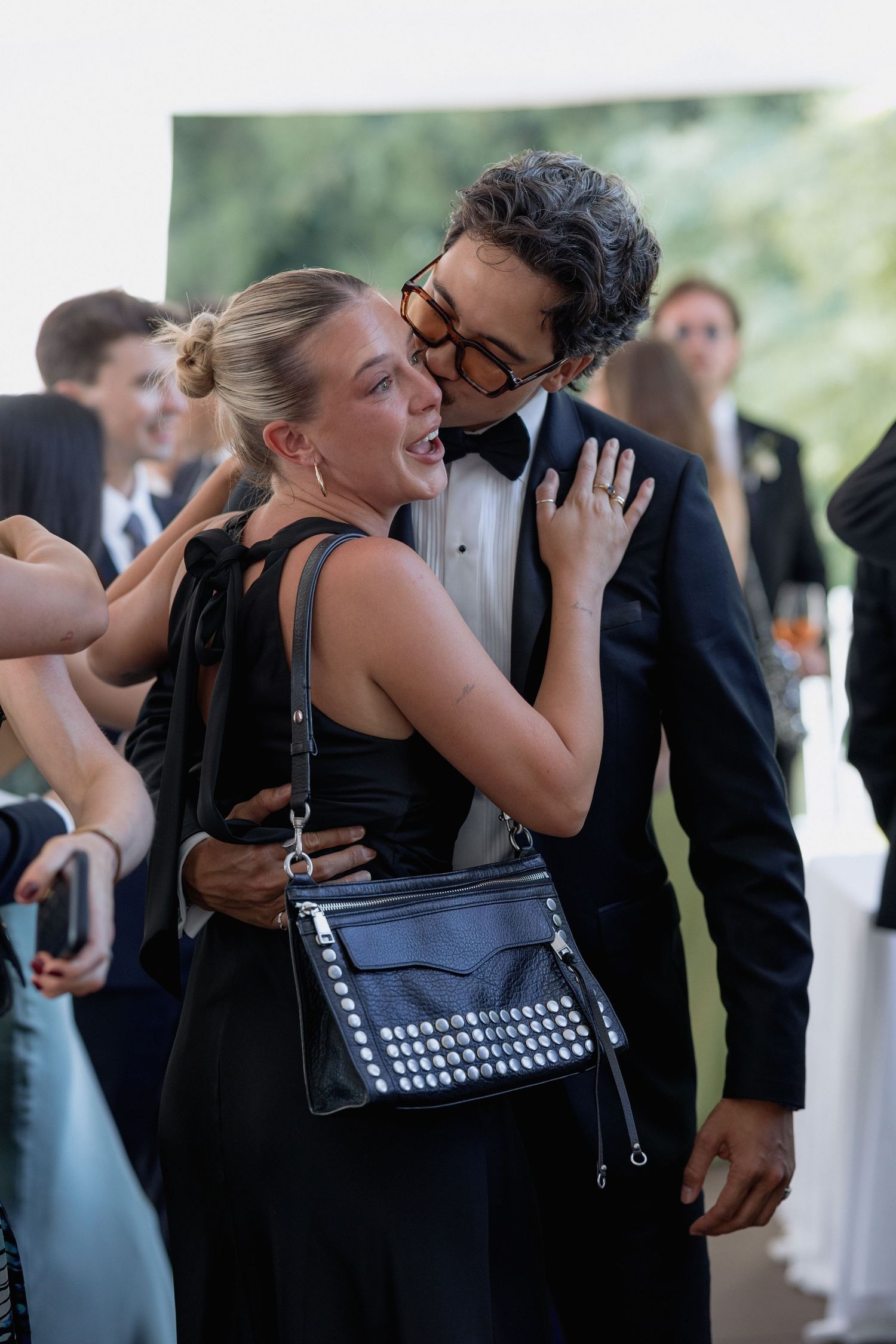 Wedding guests share intimate moments during an outdoor reception celebration.