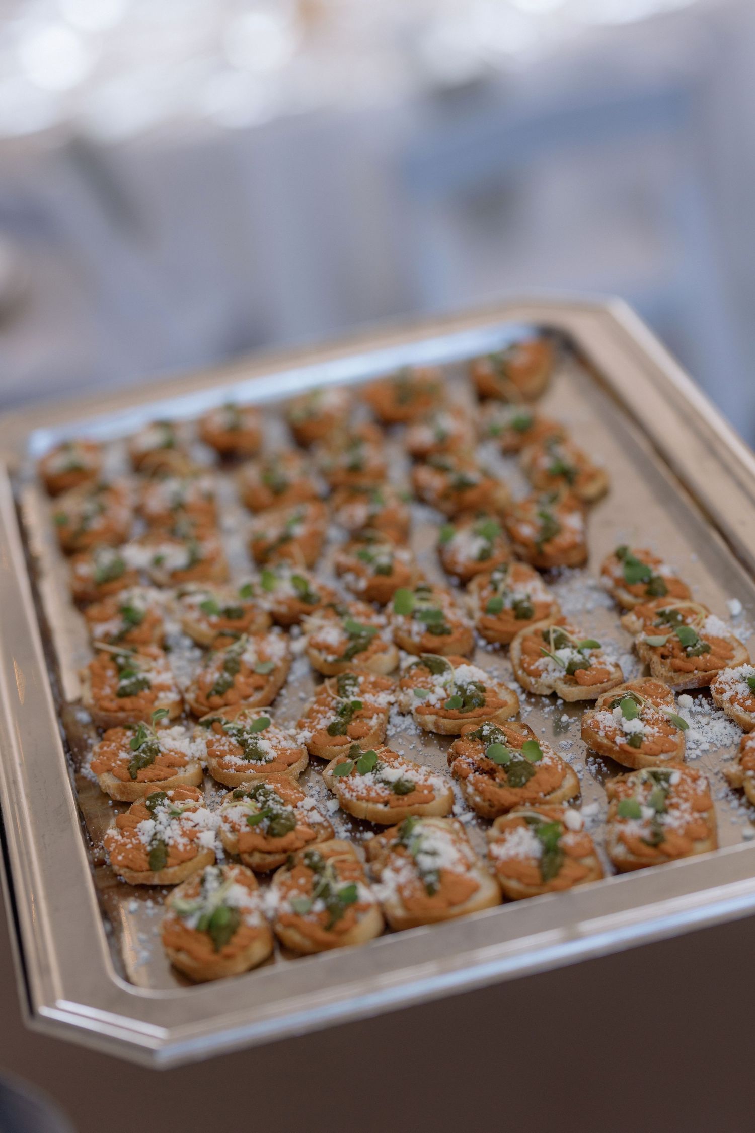 Tray of elegant canapés garnished with fresh herbs served at a formal event.