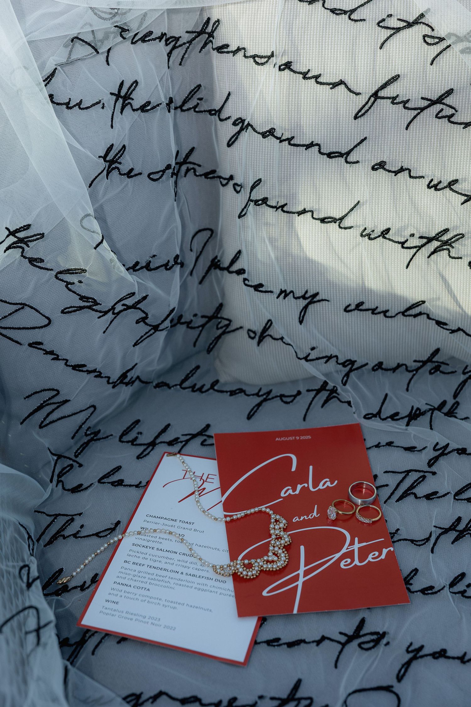 Red place cards with elegant handwritten script displayed on a background of cursive writing.