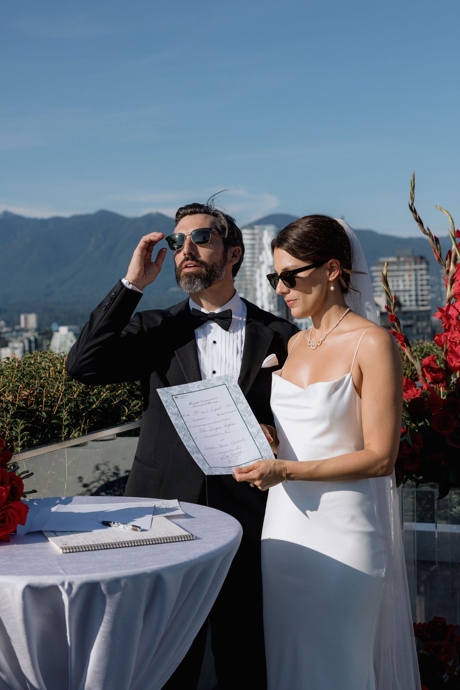 Wedding couple sharing a moment on a sunny rooftop terrace with mountain views.