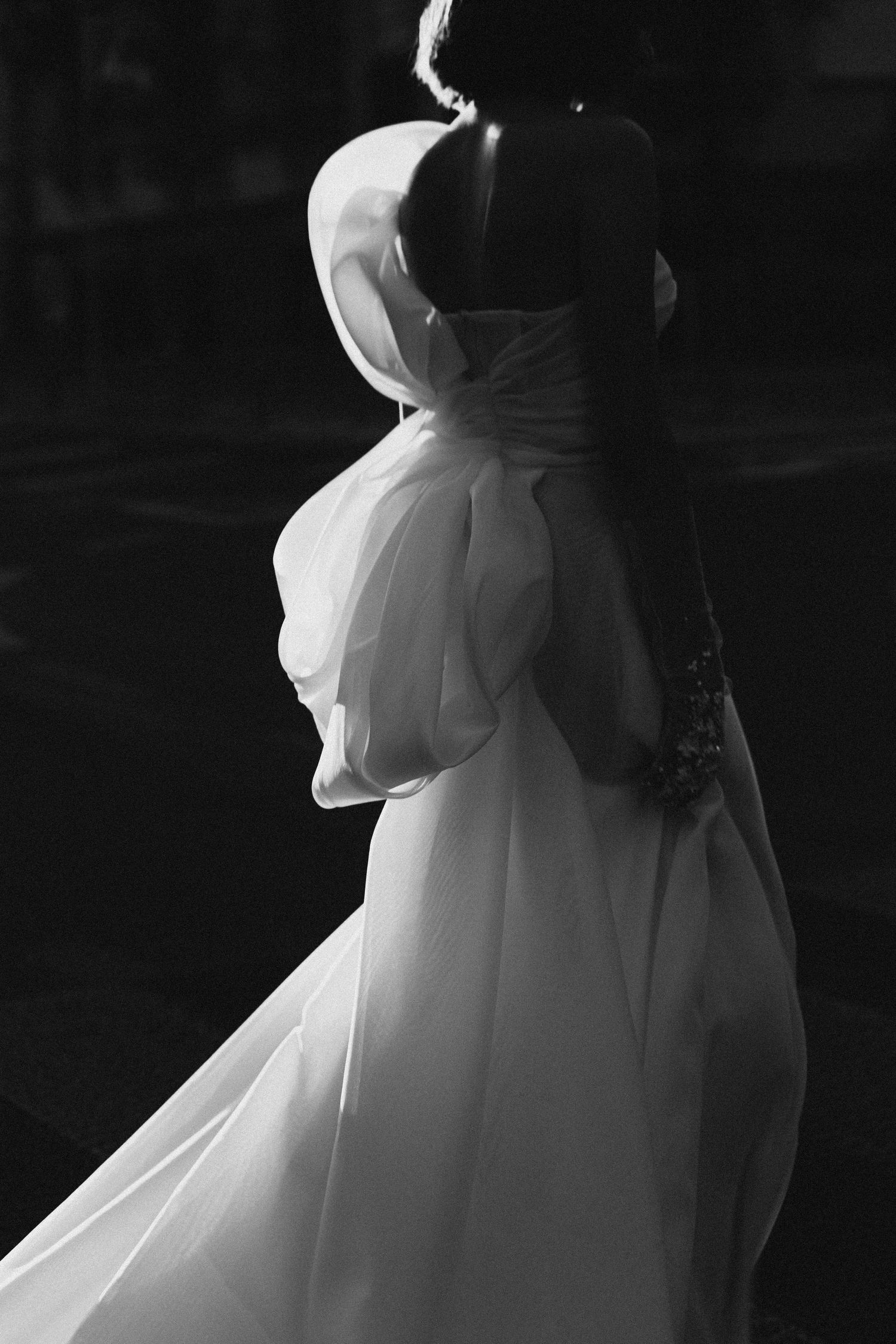 Artistic black and white shots highlighting the flowing details of a wedding dress.