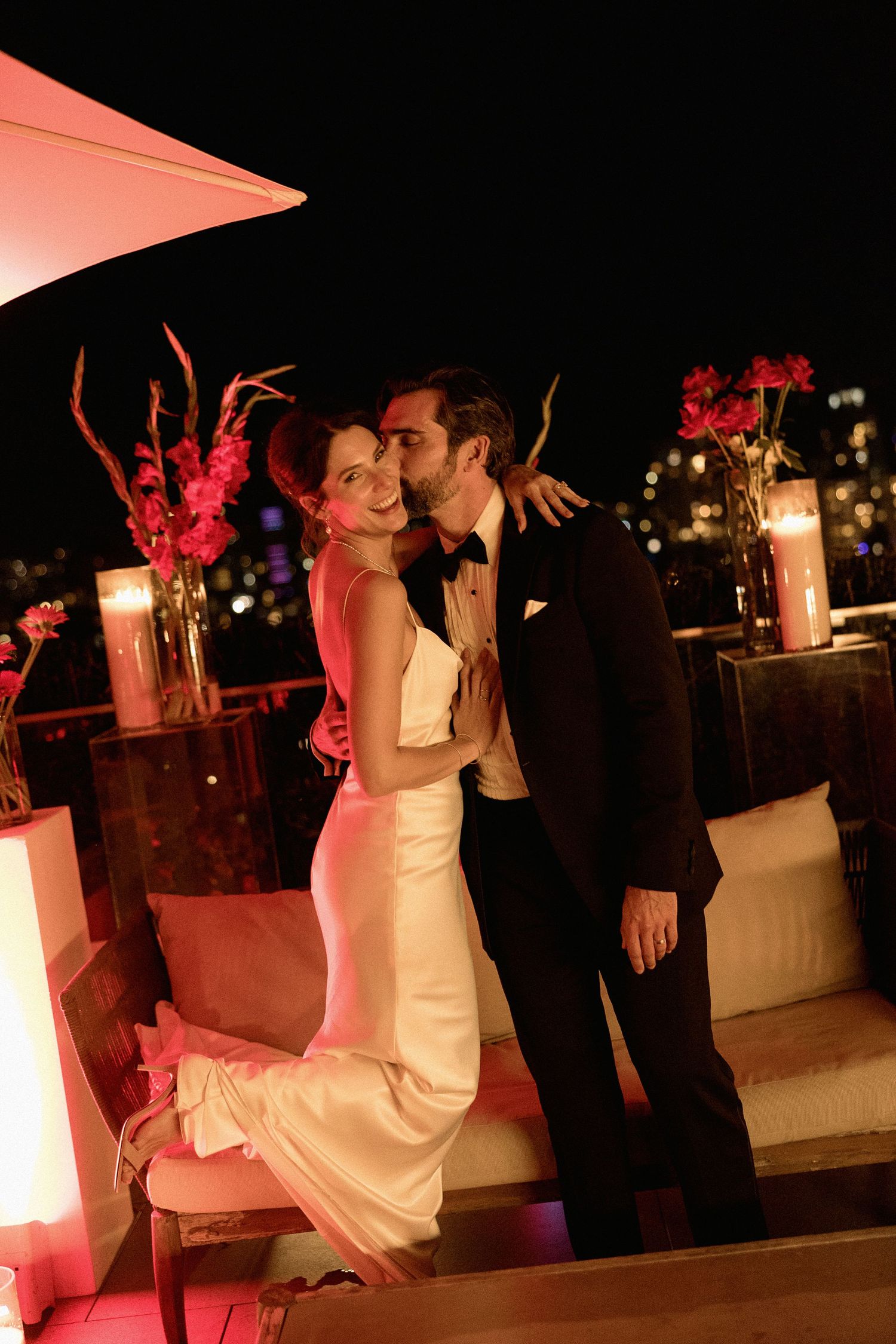 Romantic dance on a rooftop terrace with city lights and red floral decor in the night of Vancouver