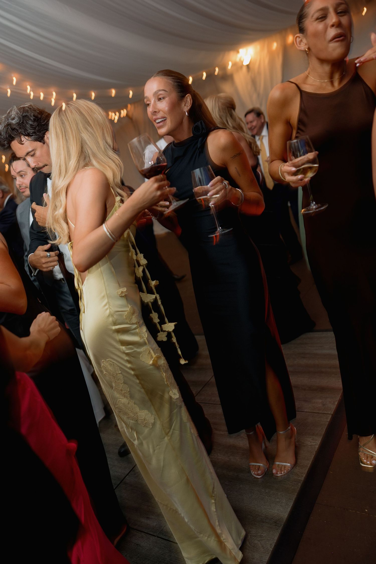 Wedding guests in formal attire dancing and socializing at an elegant evening reception.