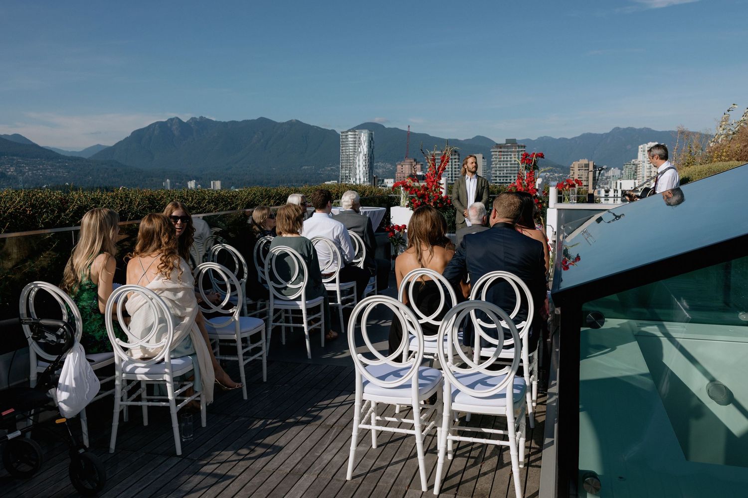 Outdoor rooftop venue with white chairs set up for an event overlooking mountain and city views of Vancouver