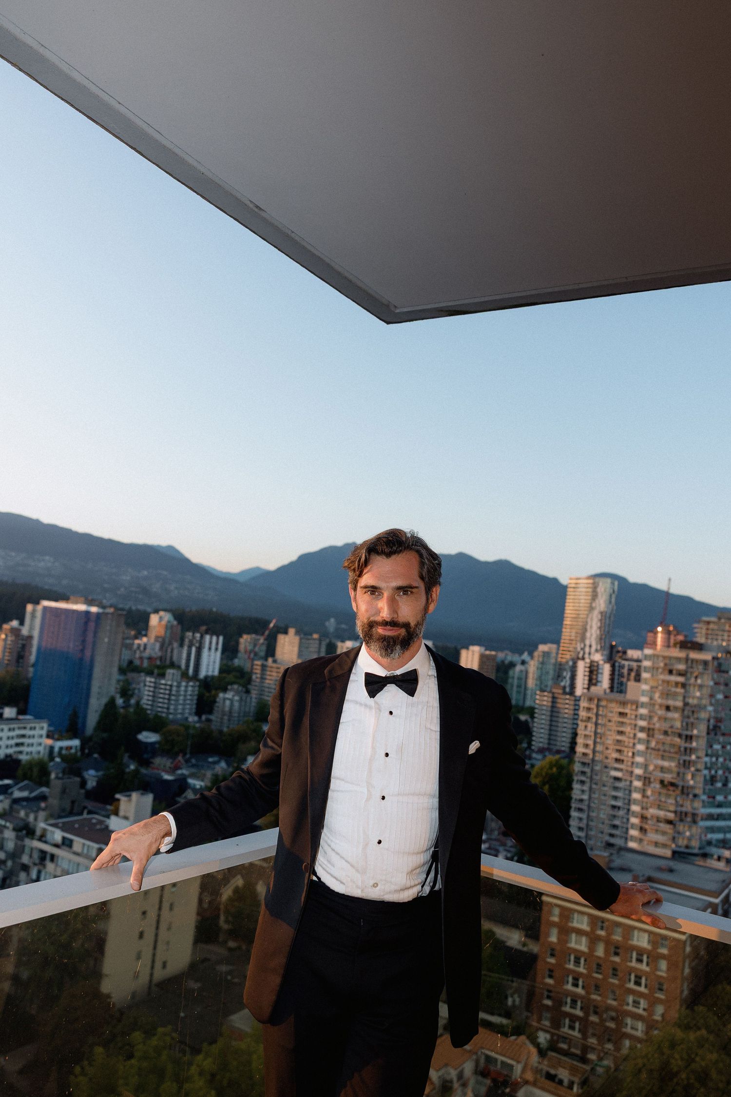 Formal event on rooftop terrace with Vancouver mountain skyline in background.