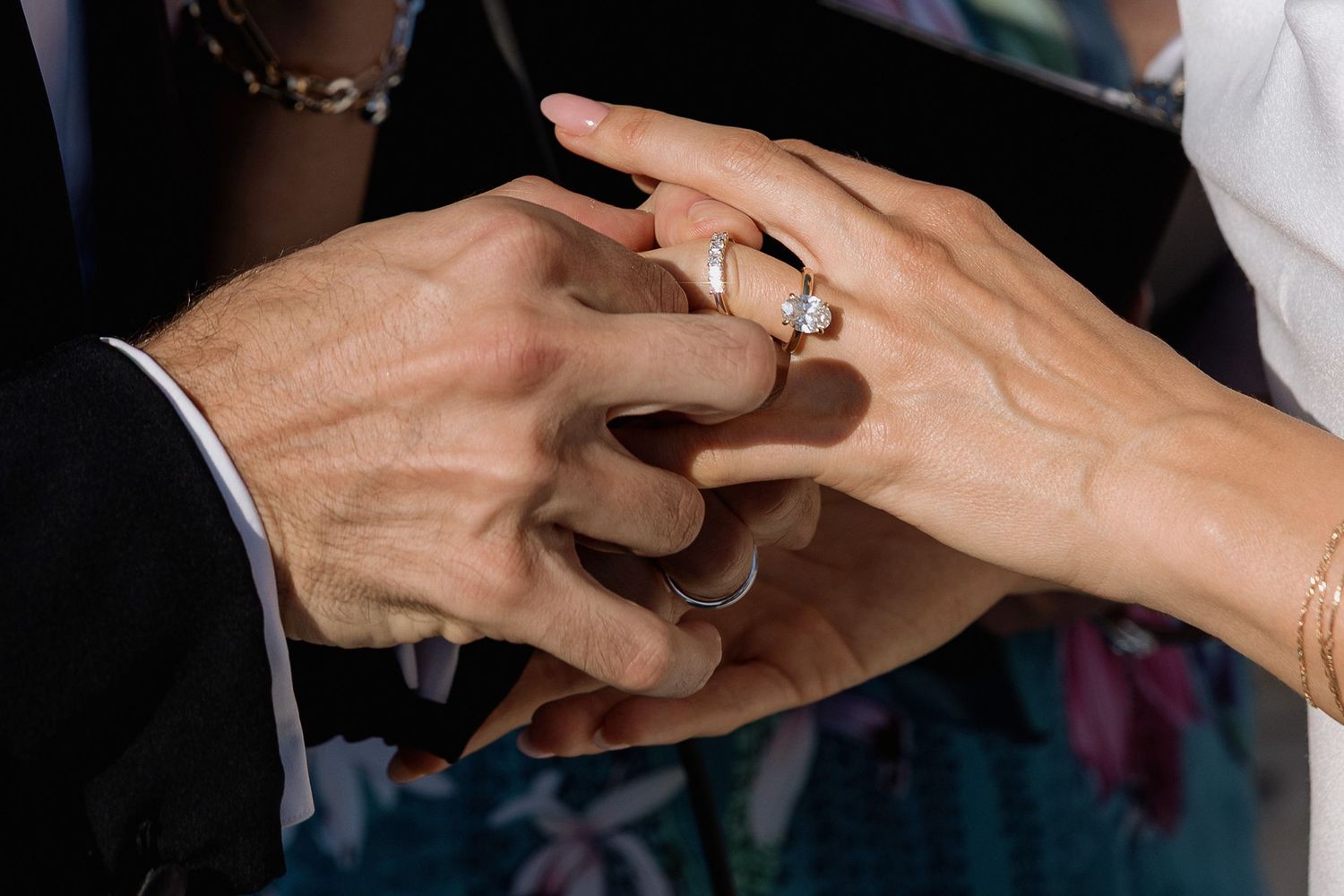 Close-up sequence showing hands exchanging wedding rings during a marriage ceremony.
