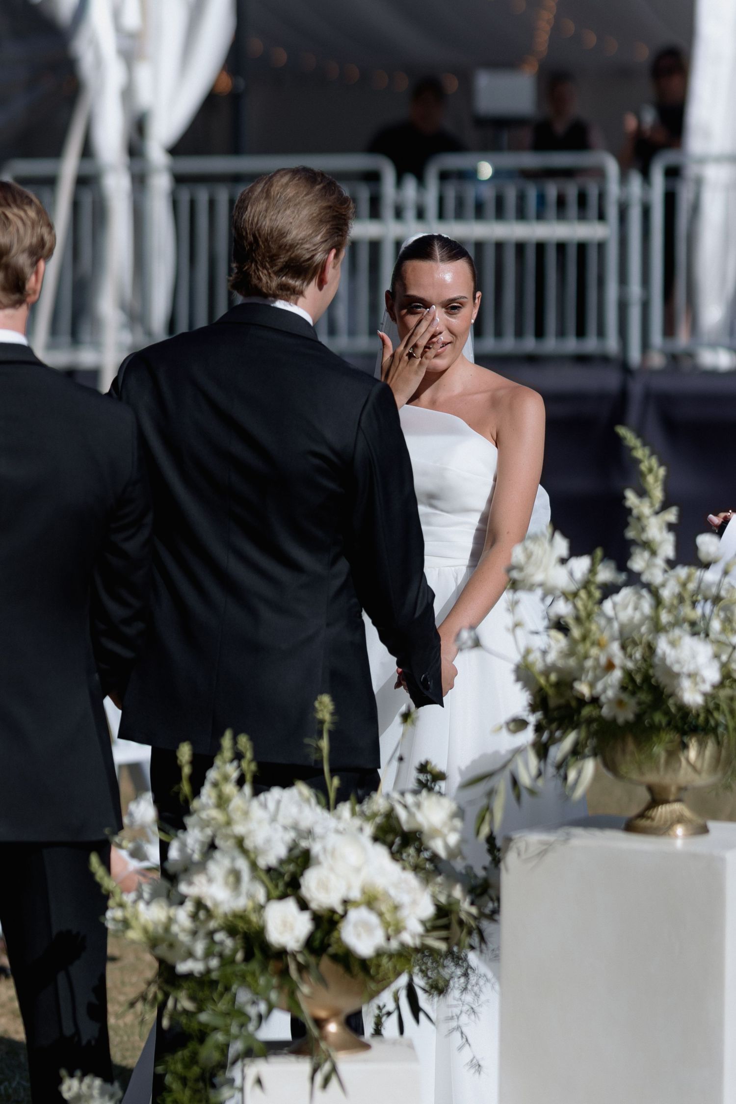 White floral arrangements decorating an outdoor wedding ceremony space.