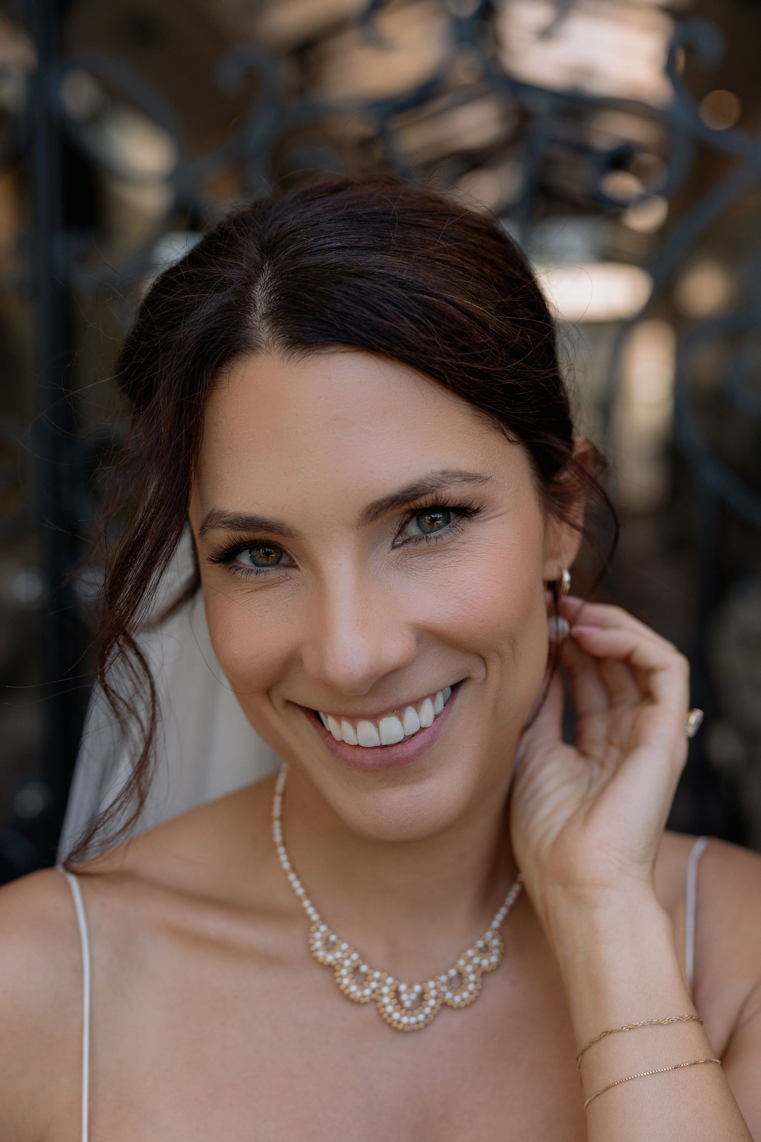 Candid bridal portrait featuring a delicate crystal necklace and natural smile.