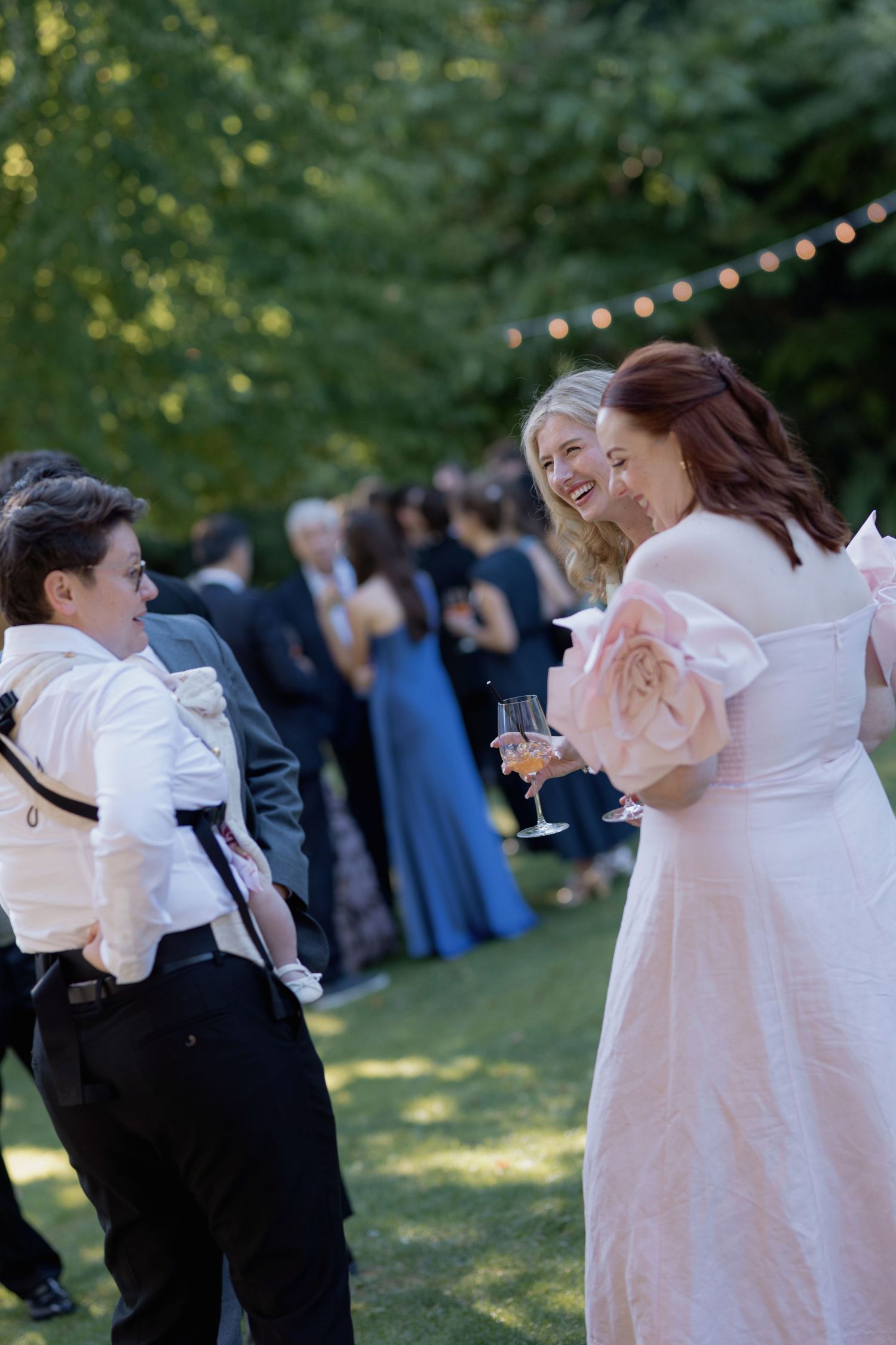 Wedding guests dancing and celebrating at an outdoor evening reception.