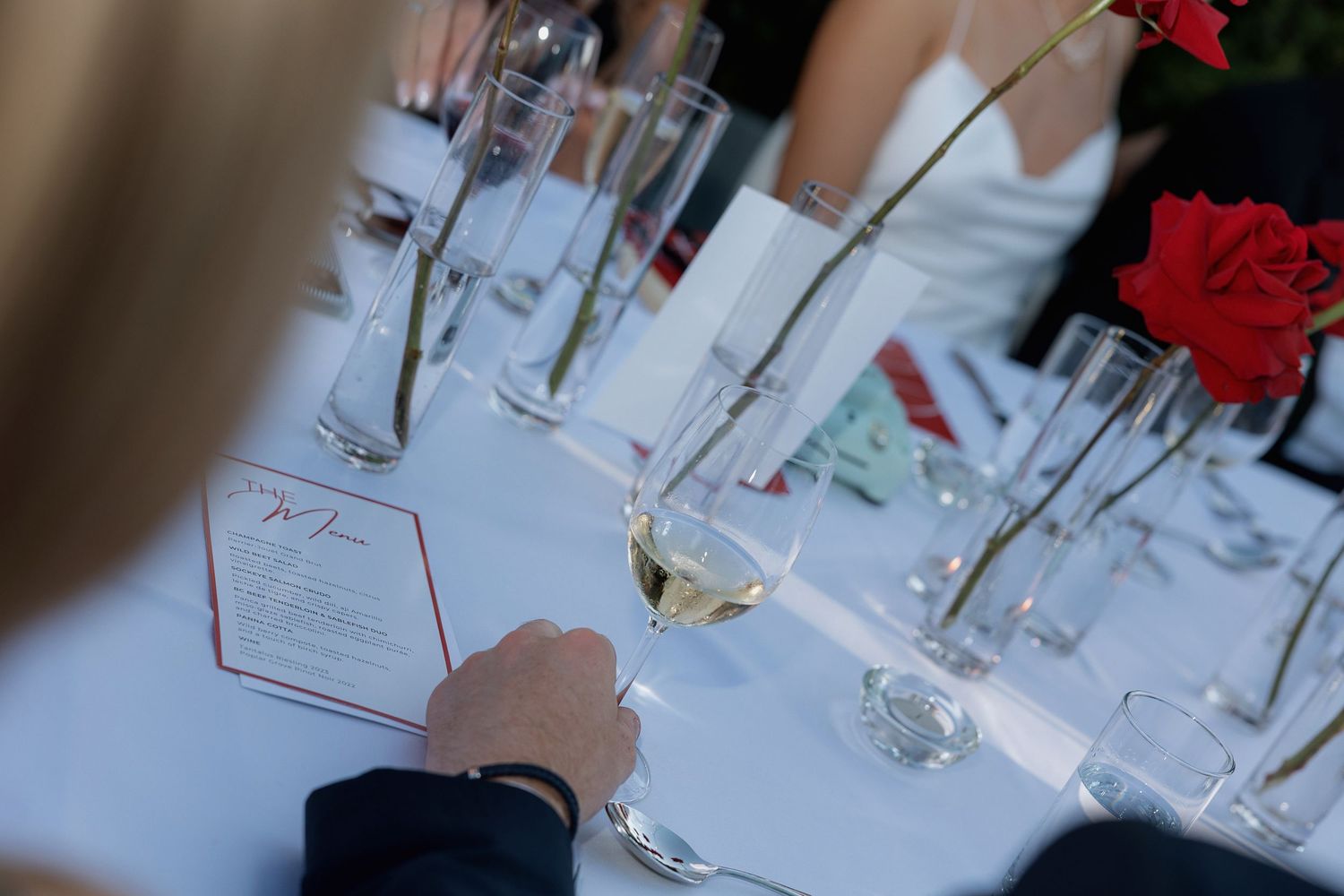 Close-up of elegant place settings with wine glasses at wedding reception.