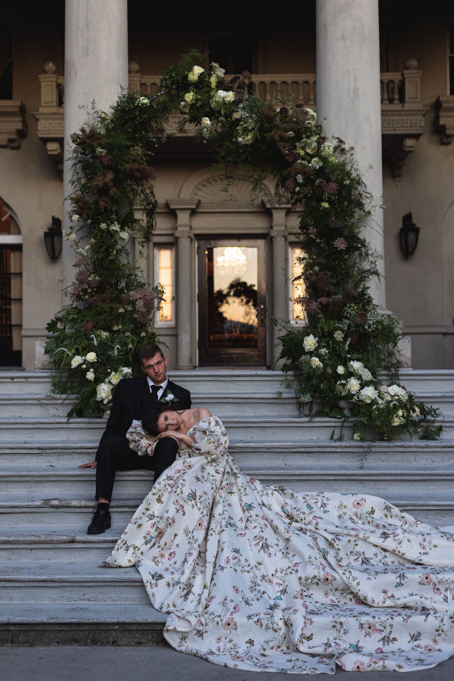 Classical columned portico decorated with climbing roses and floral arrangements.