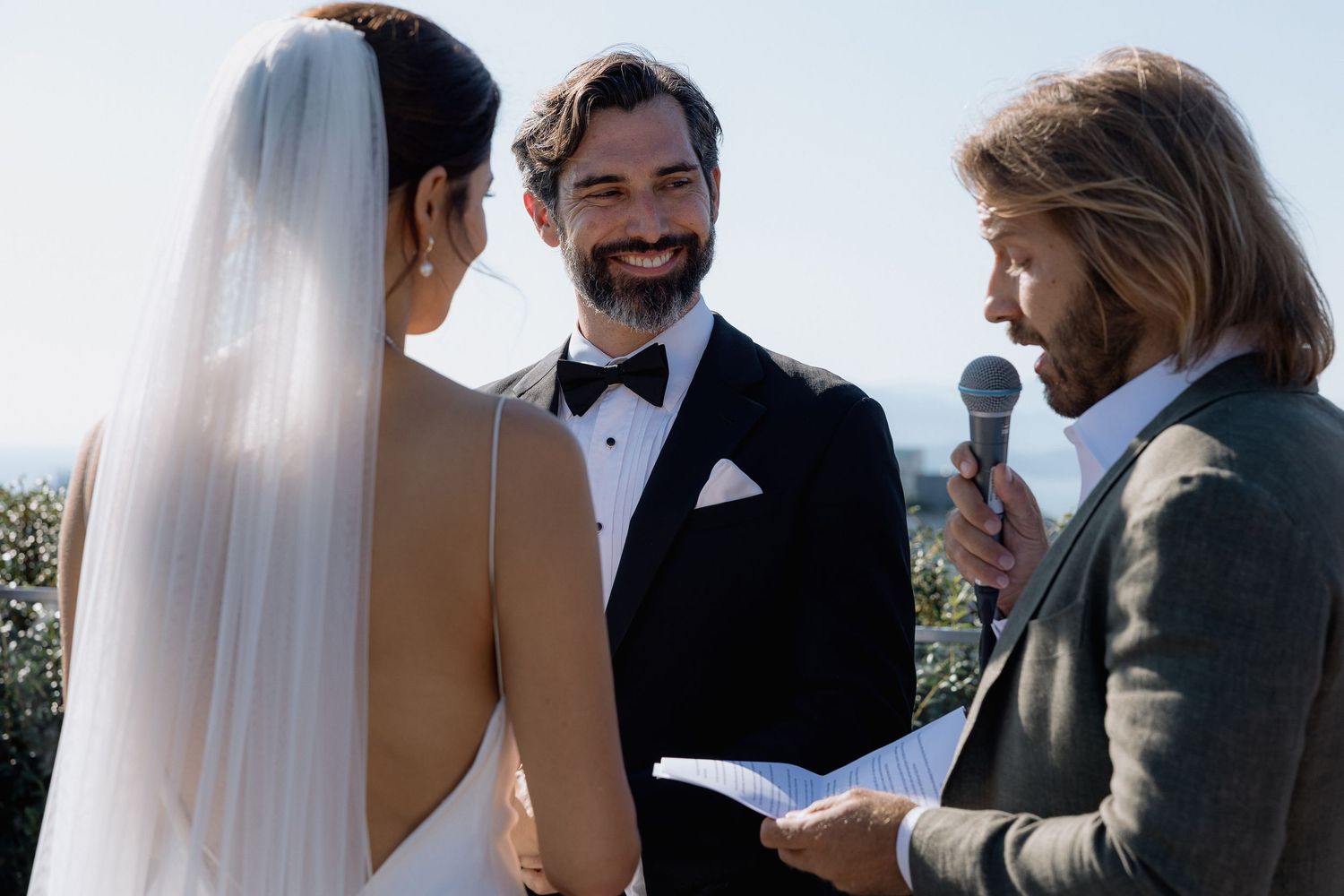 Wedding ceremony in progress with guests gathered on a rooftop venue.