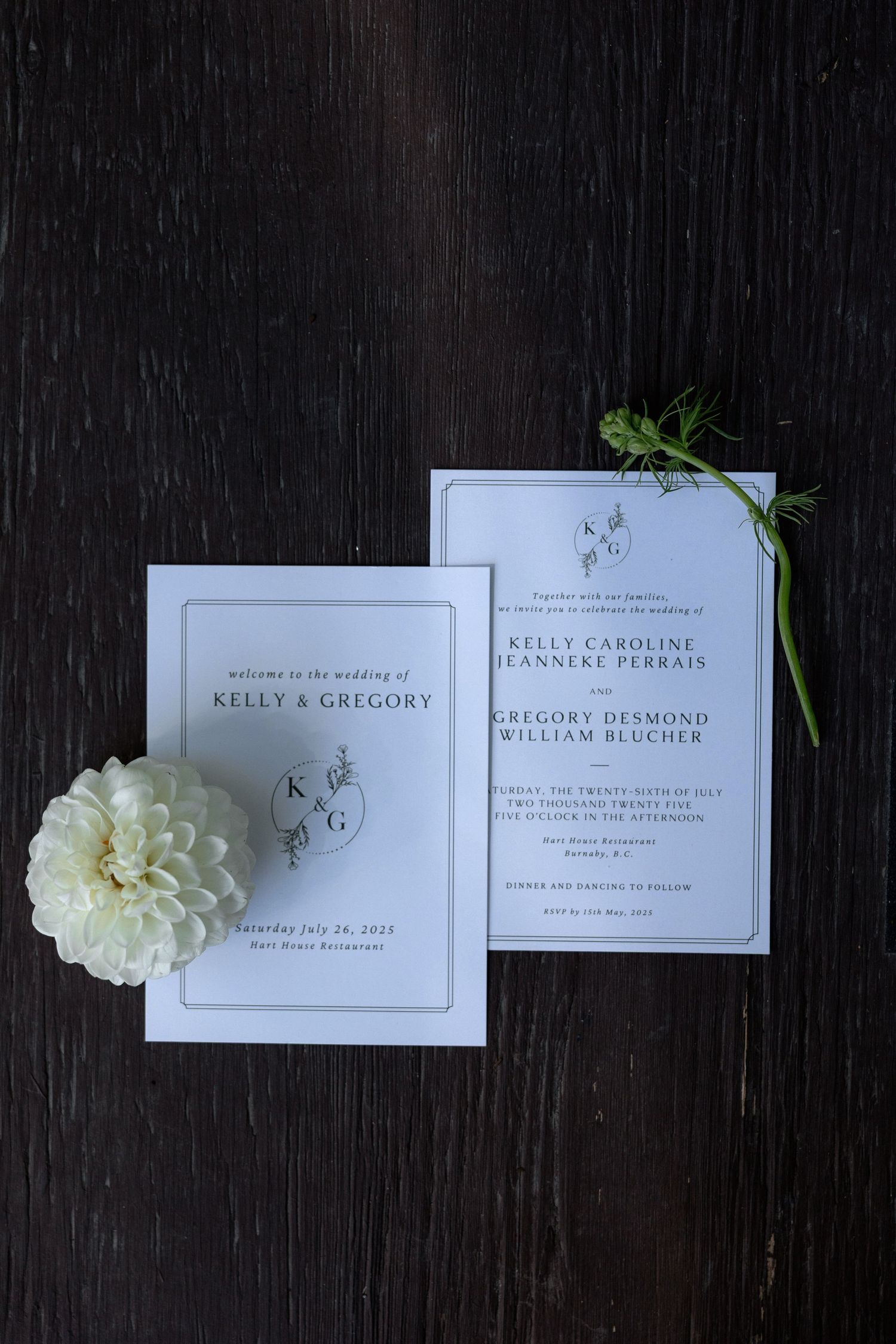 Wedding invitation suite with white carnation and delicate greenery on dark background.