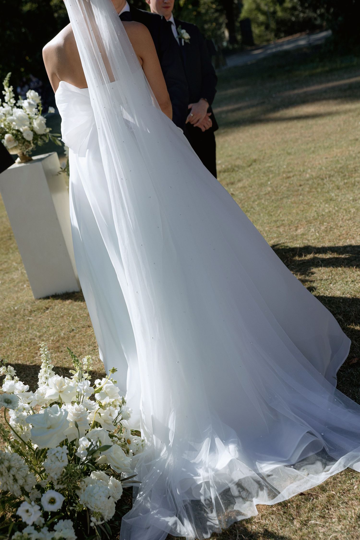 Close-up of a flowing white wedding dress with delicate tulle details.
