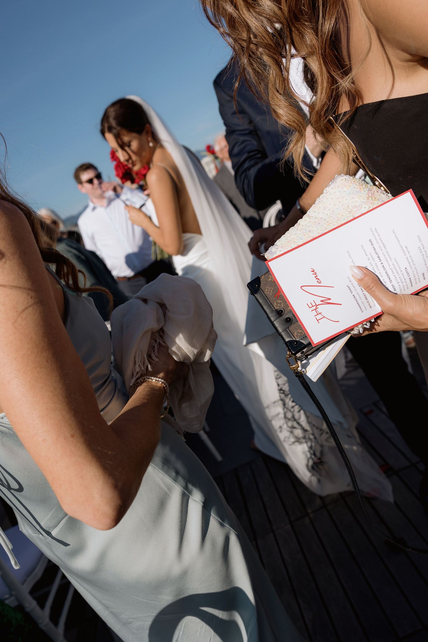 Wedding guests signing documents during outdoor rooftop celebration.