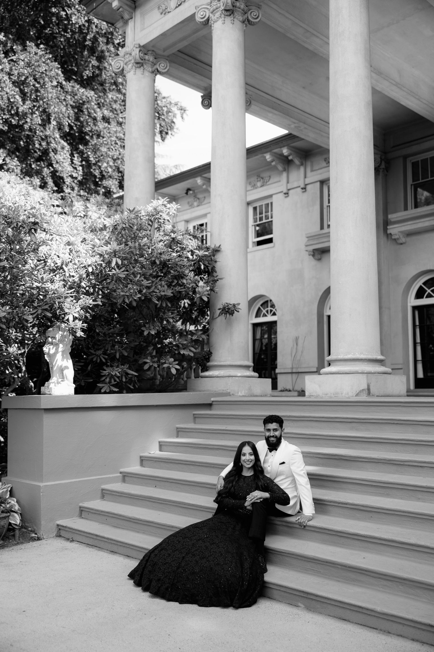 A series of four black and white photos showing a couple and their dog posing on white columned porch steps.