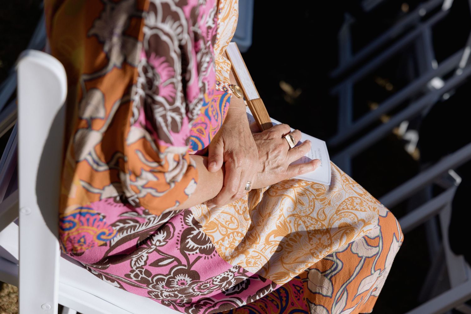 Detail shot of colorful floral patterned fabric with pink and orange tones.