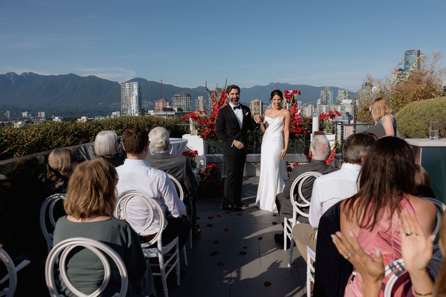 Panoramic view of a rooftop gathering with mountains and city skyline in the background.