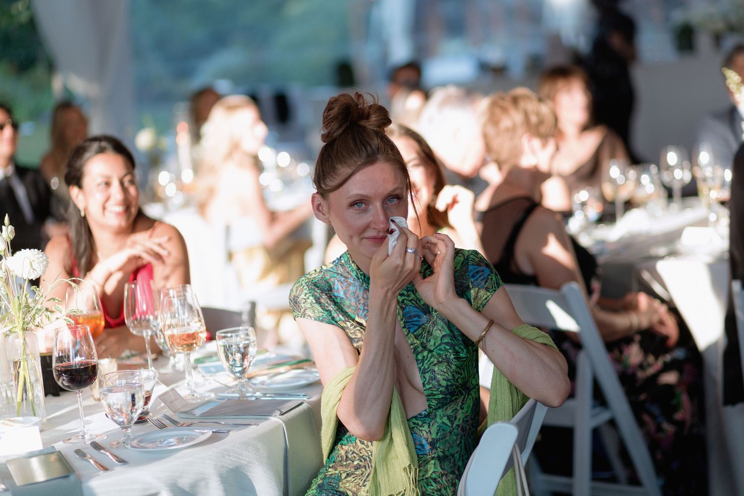 Wedding reception guests engaged in lively conversation at decorated tables.