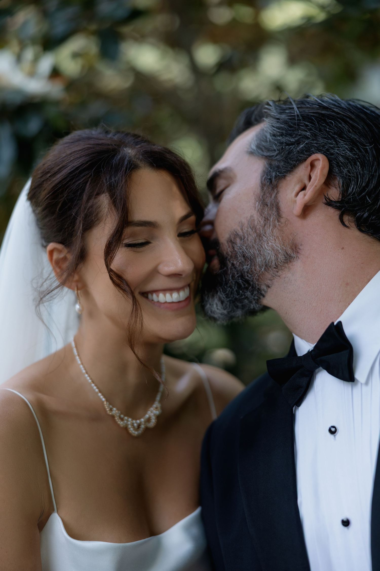 A romantic wedding moment captured outdoors with the couple in formal attire sharing an intimate moment.