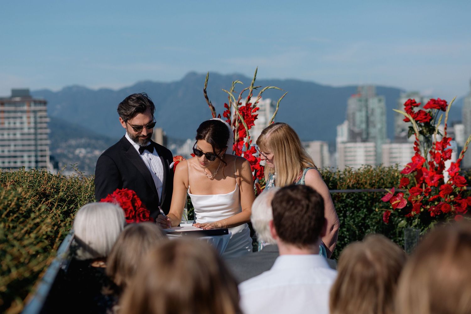 Outdoor wedding ceremony setup with mountain and city skyline views in the background.