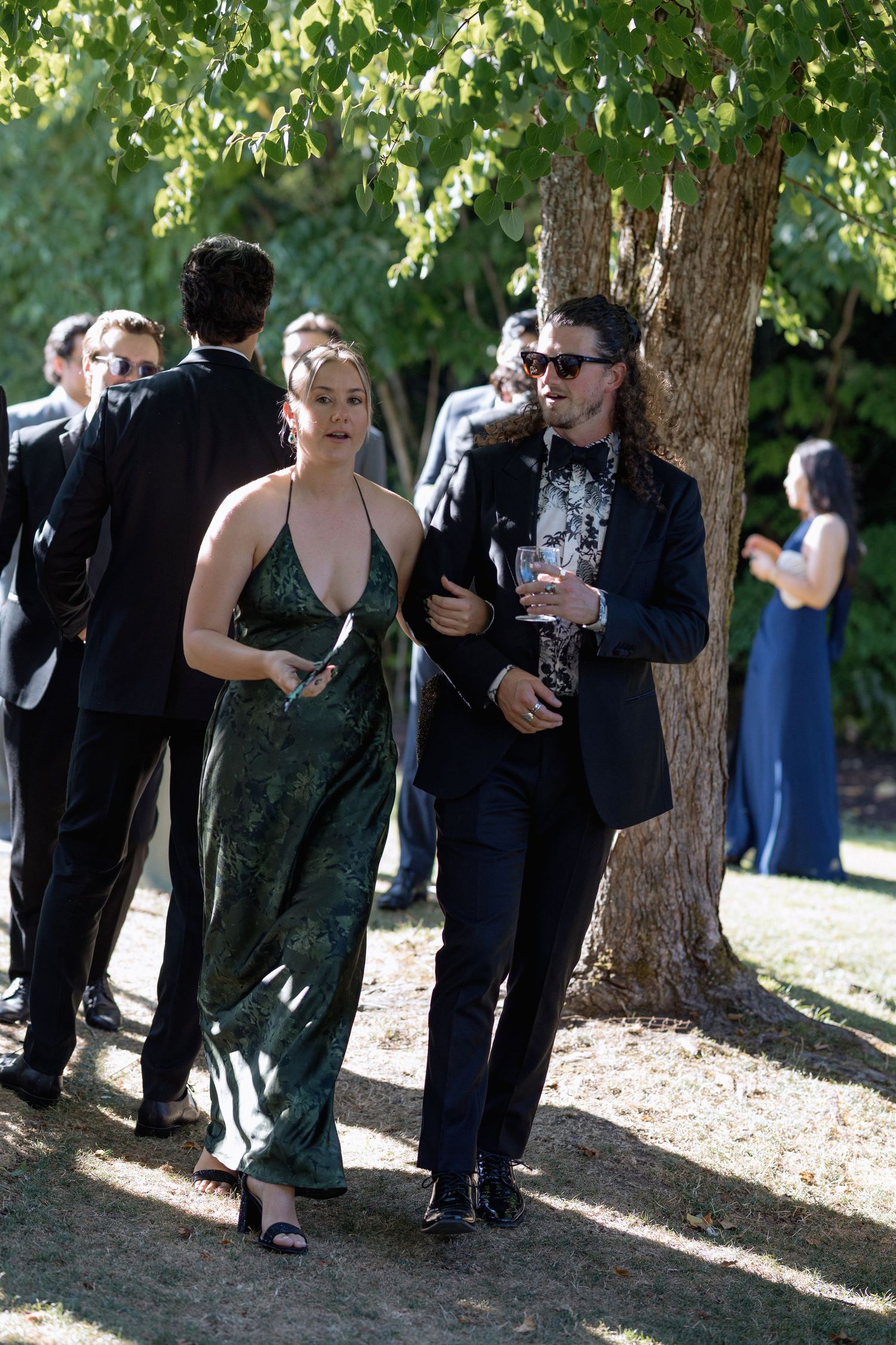 Well-dressed couple walking together at an elegant outdoor event.