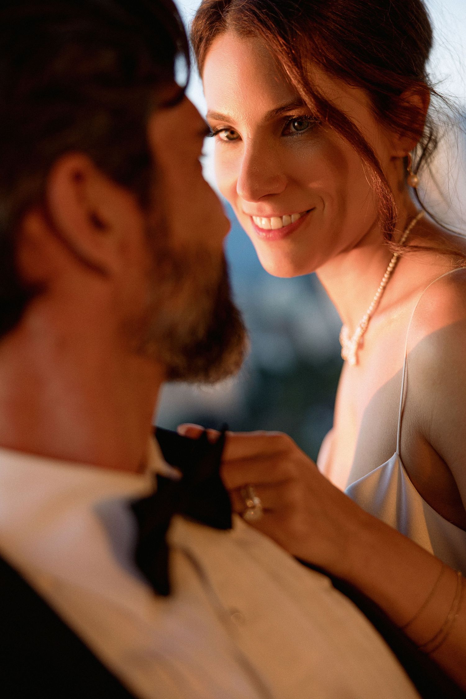A romantic moment between a couple in formal attire with soft lighting and warm tones.