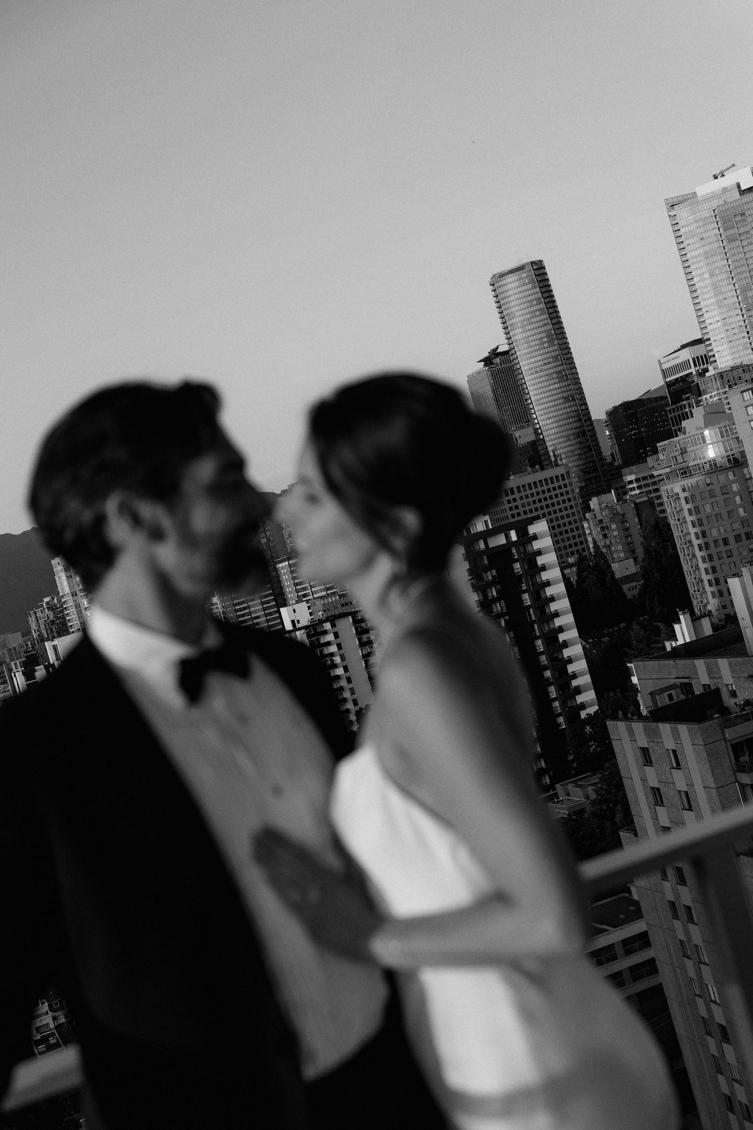 Silhouetted figures embracing with urban high-rises visible in the background.