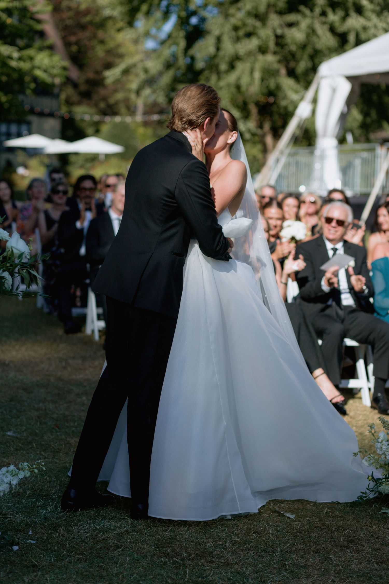Close-up view of a white wedding dress swaying during an outdoor dance.