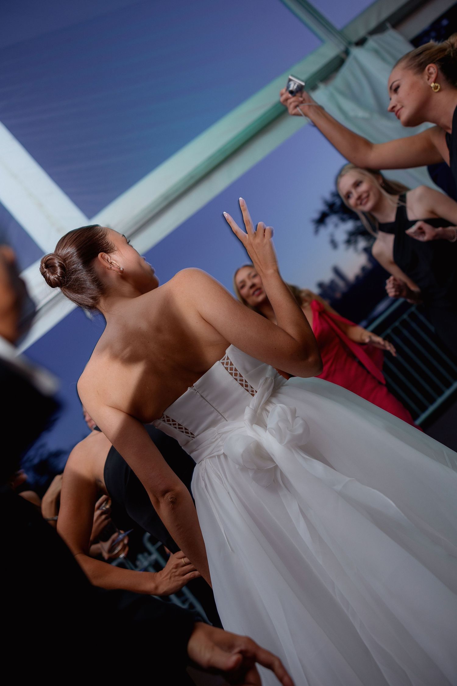 Bride striking a playful dance pose during wedding reception festivities.
