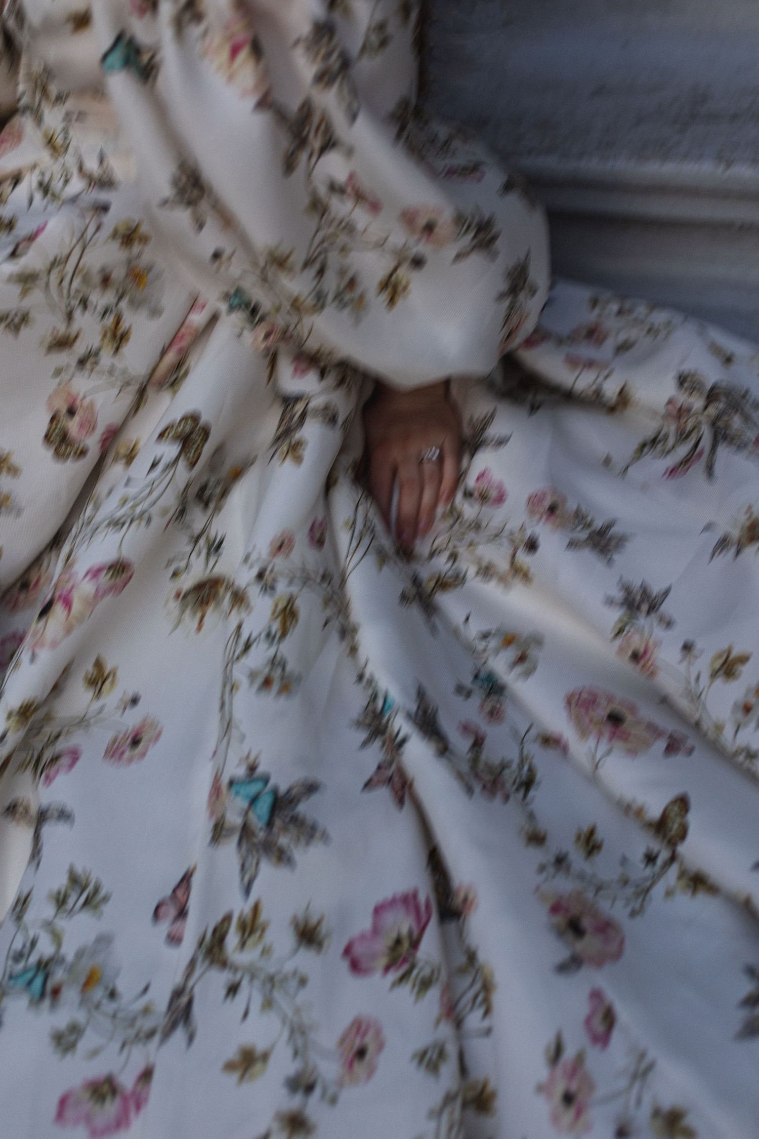 Close-up detail of delicate floral pattern on white fabric with intricate embroidery.