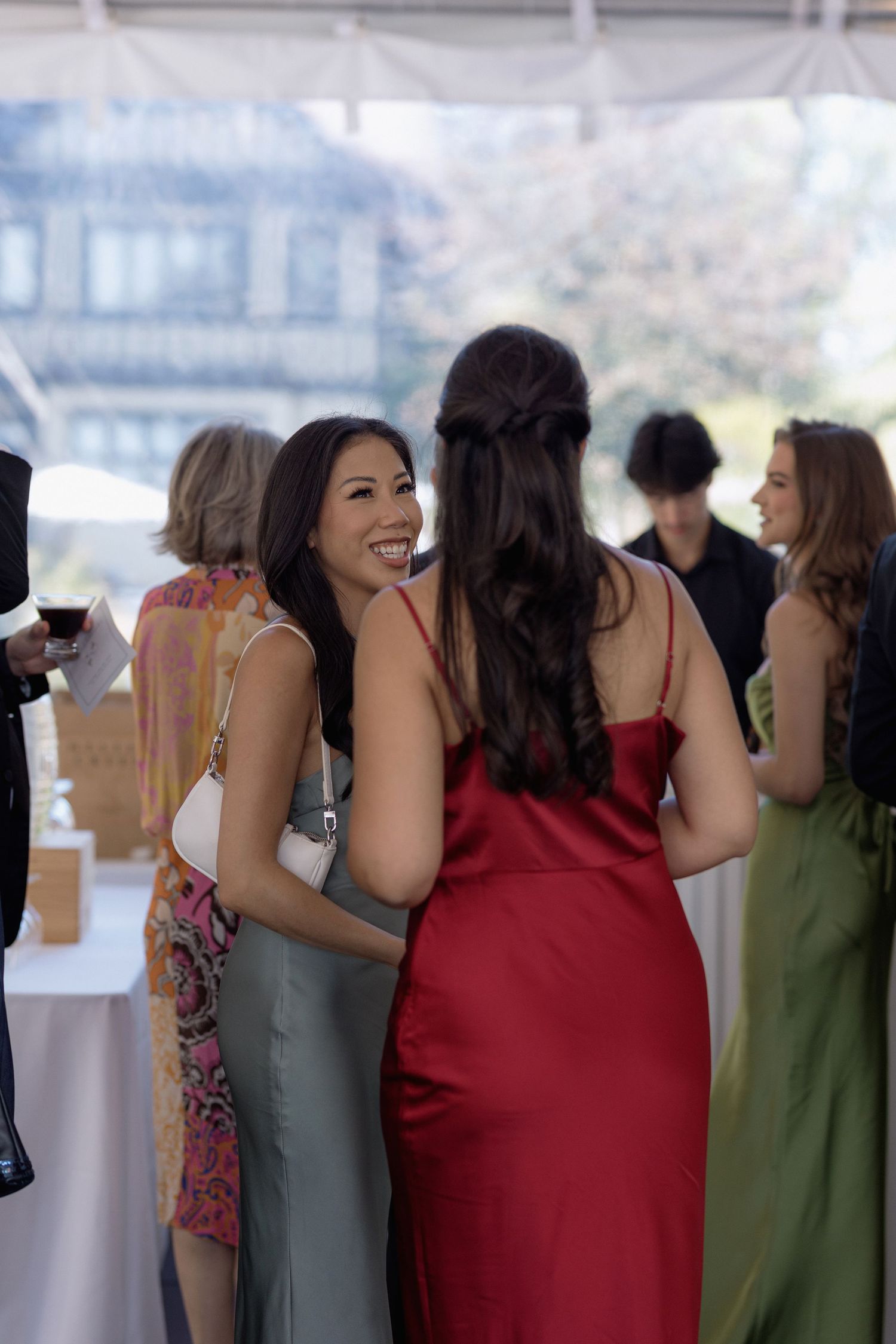 Guests in formal attire sharing laughter at an elegant reception.