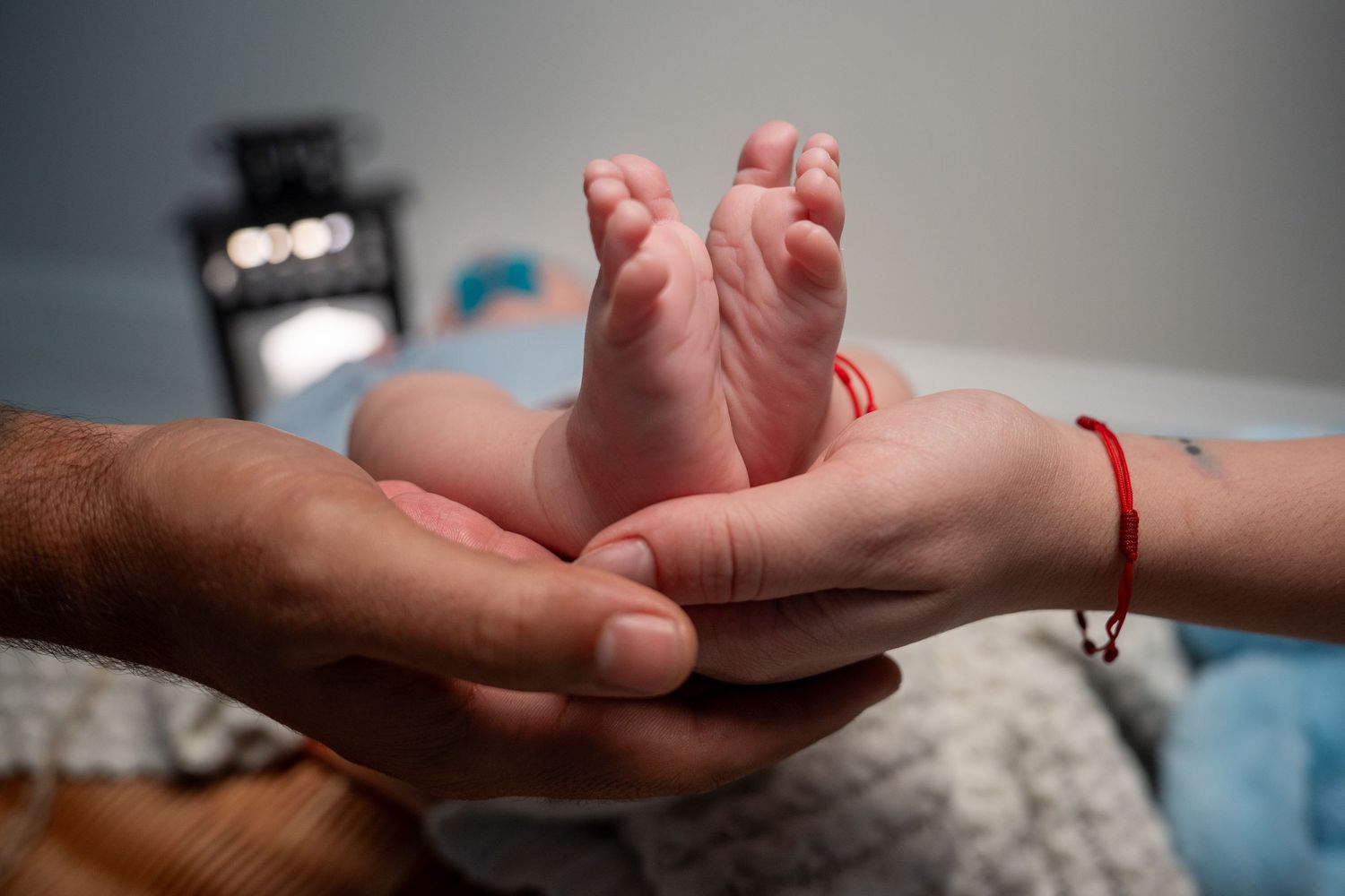 South Florida newborn photography of parents holding baby’s feet together