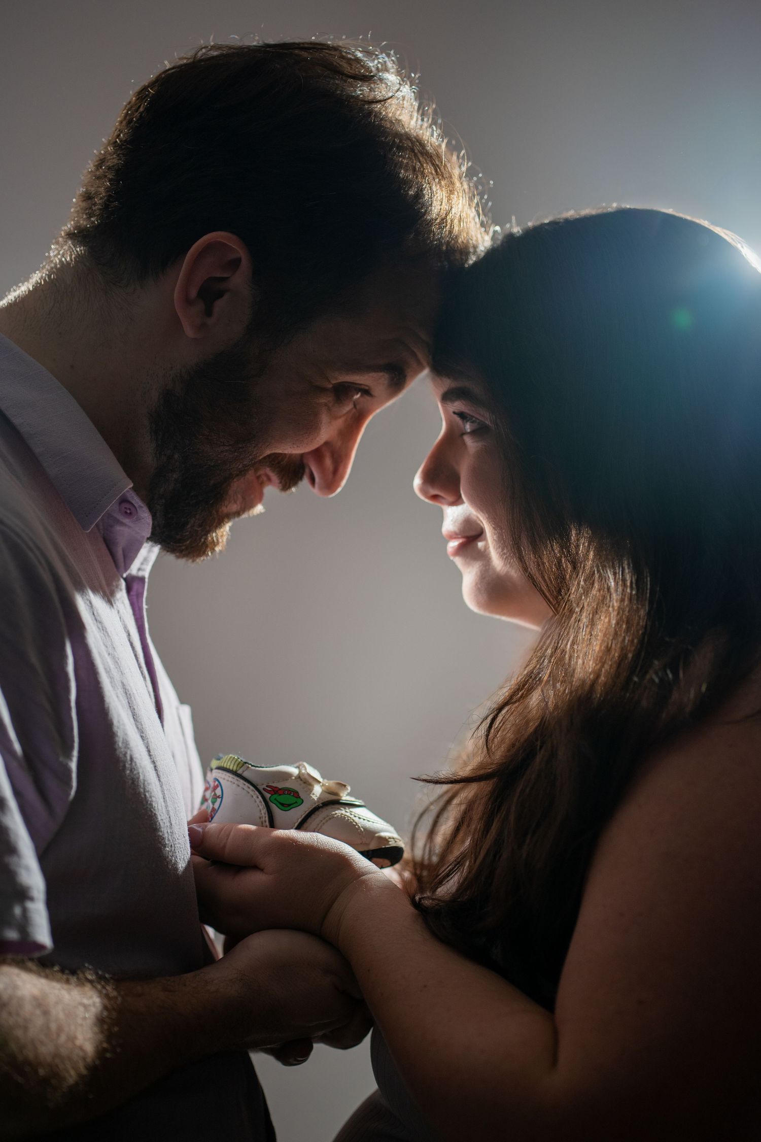 Studio maternity portrait of an expecting couple sharing an intimate moment, captured with soft lighting, editorial style in fort lauderdale