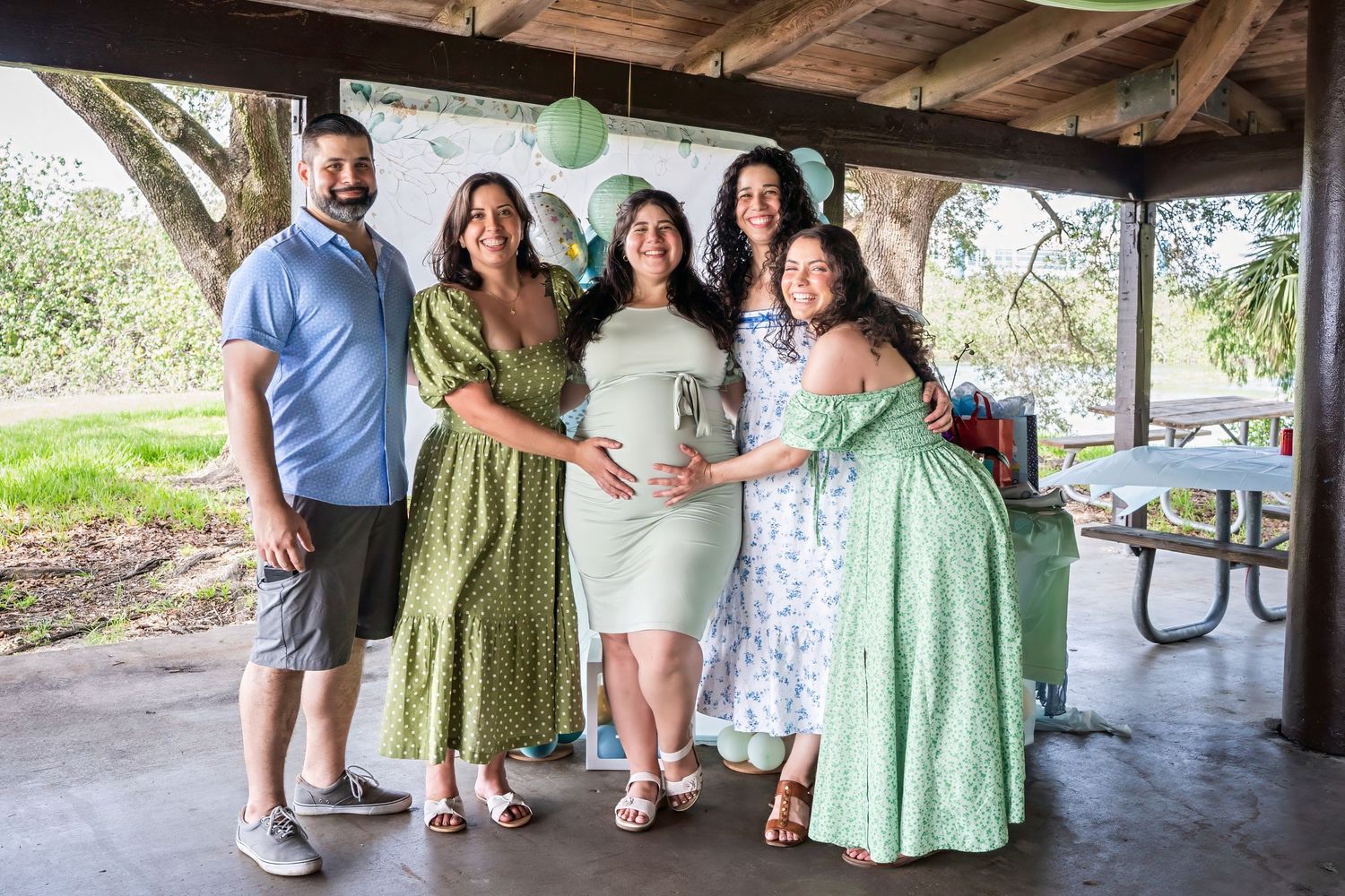 Group portrait celebrating an expecting mother at an outdoor baby shower in South Florida.