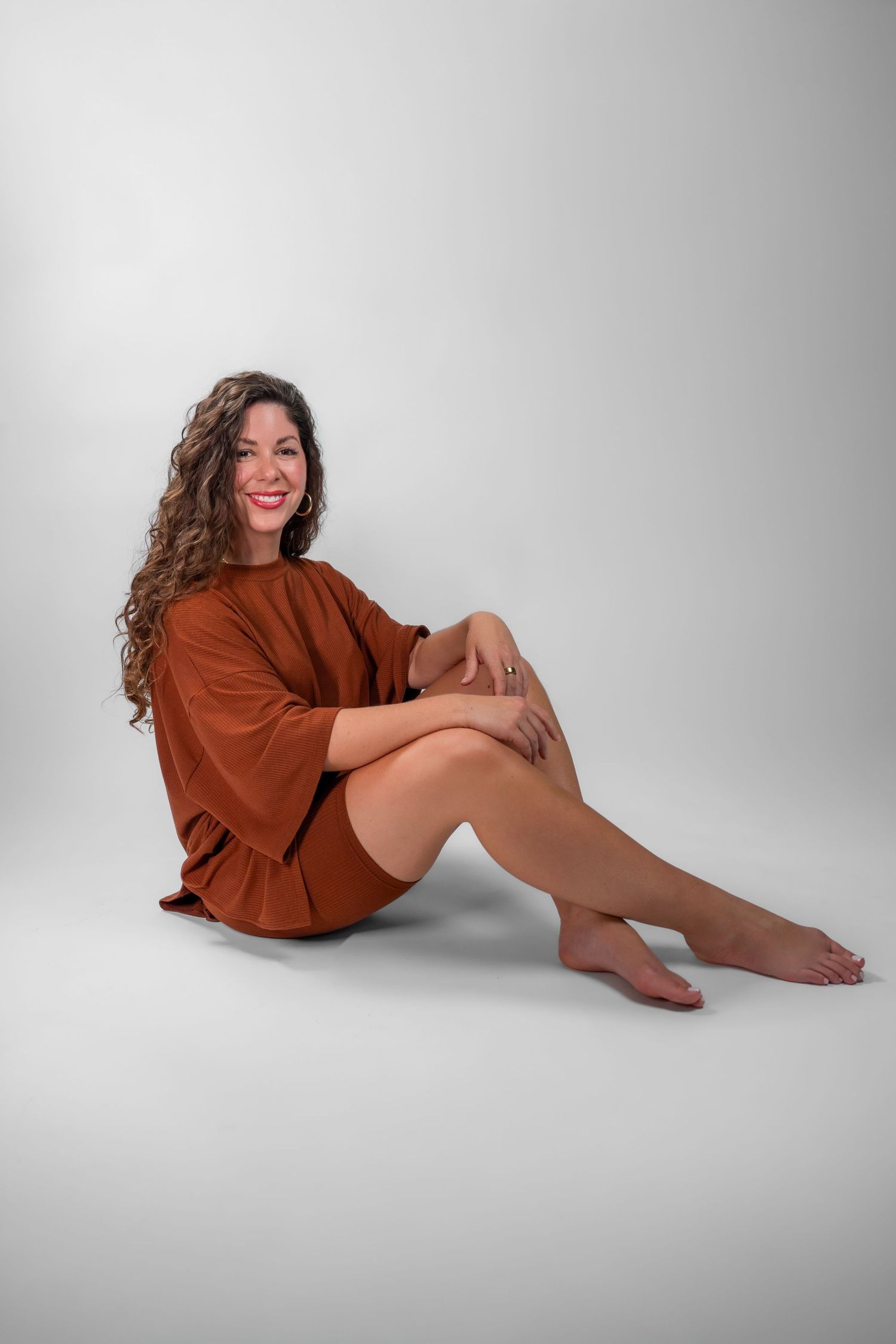 South Florida studio headshot of woman seated on floor in rust outfit with neutral backdrop

Fort Lauderdale Photographer