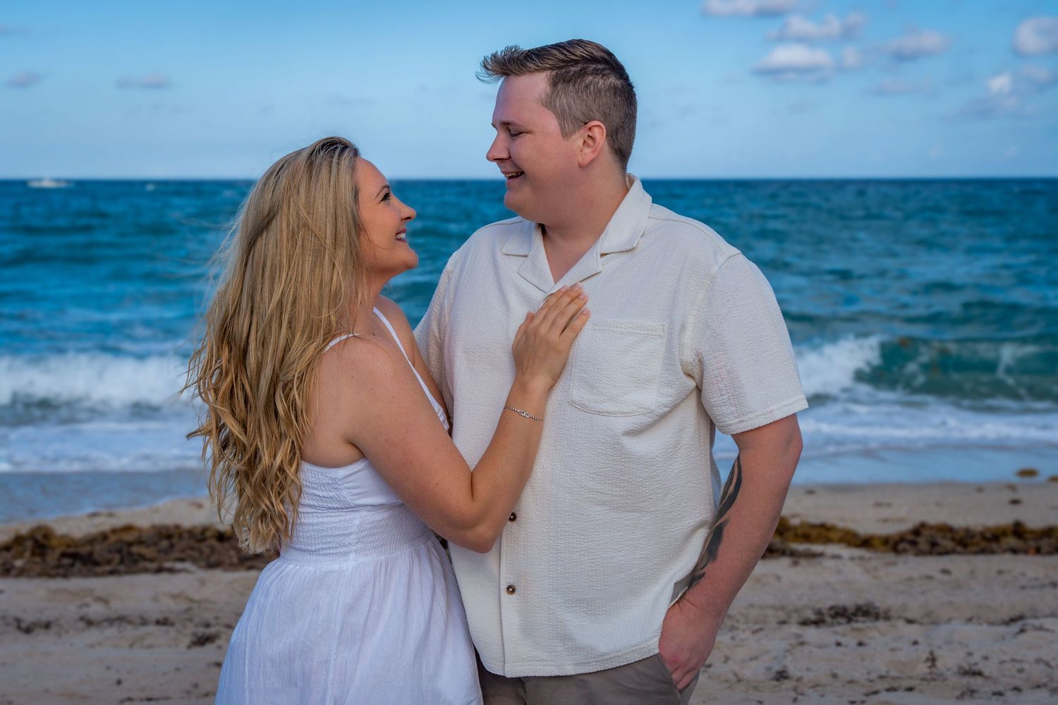 Engagement session by the ocean, capturing the joy of a couple celebrating their love on the beach.