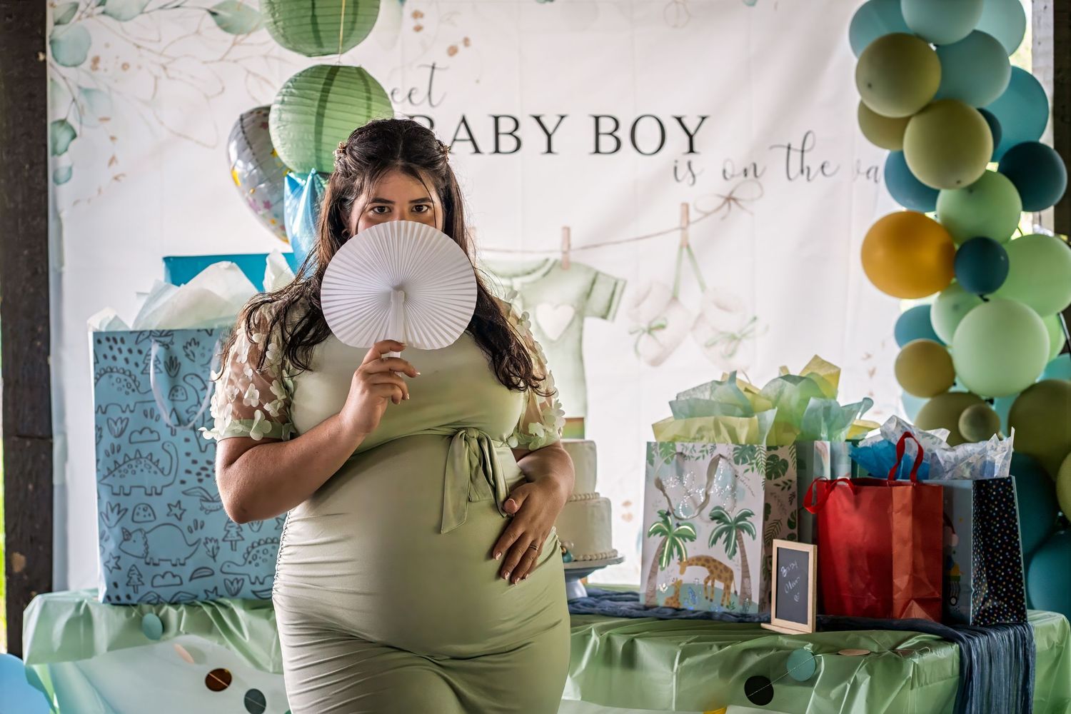 Expecting mother holding a playful prop during a baby shower photoshoot in South Florida.