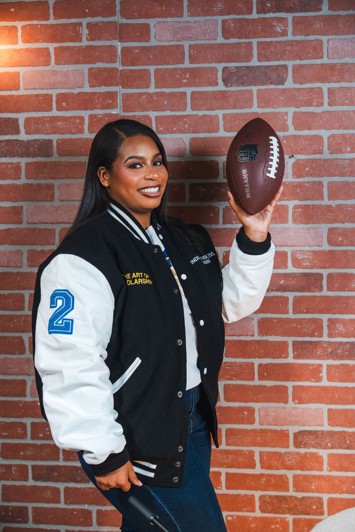 Personal brand photography of a scholarship coach holding a football during a creative entrepreneur branding session.