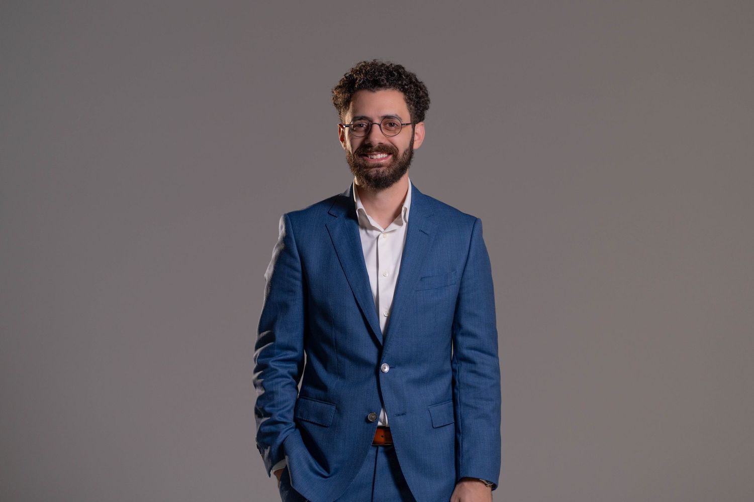 Man in blue suit smiling during studio portrait session