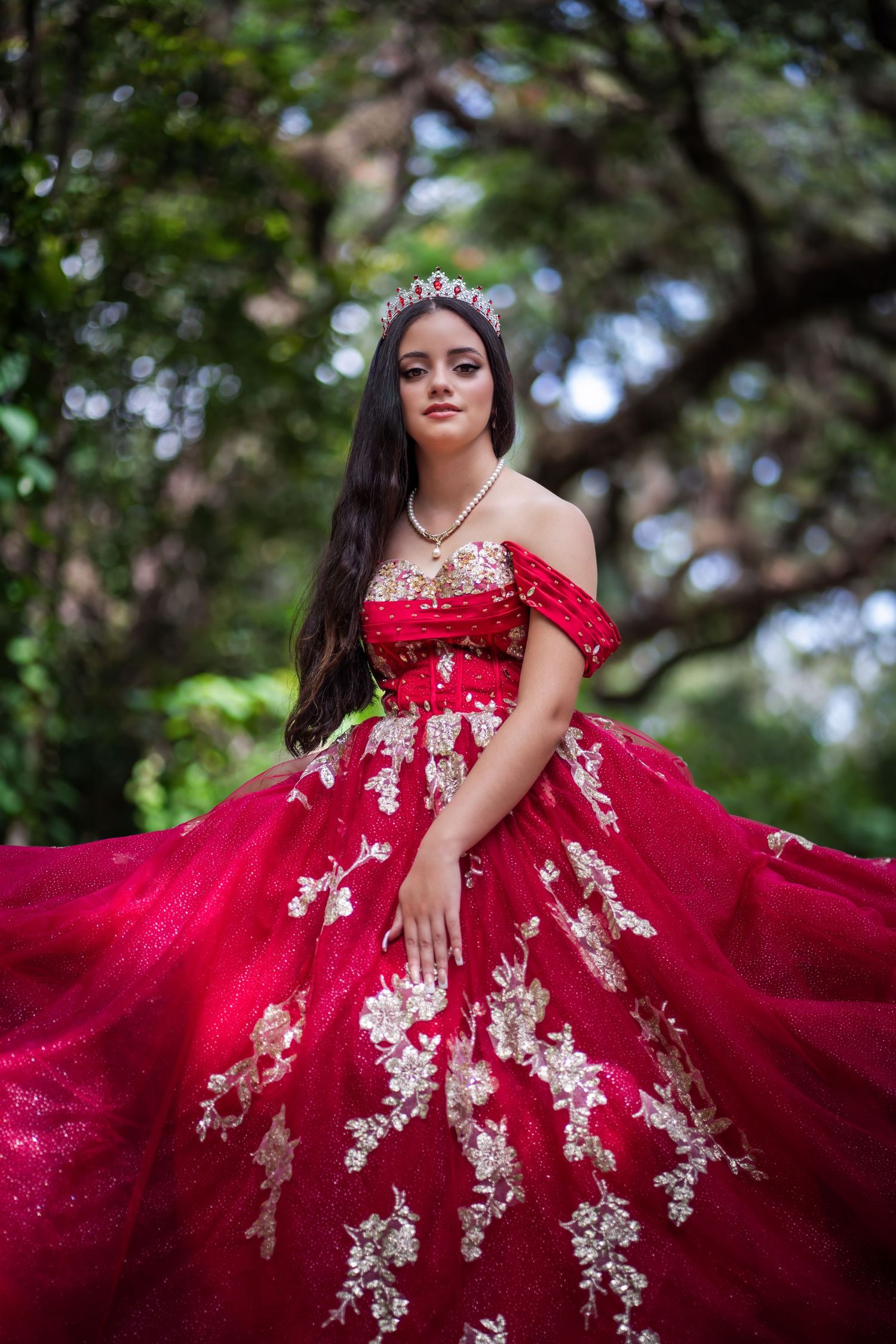 Elegant red and white Quince dress portrait surrounded by trees in South Florida.
