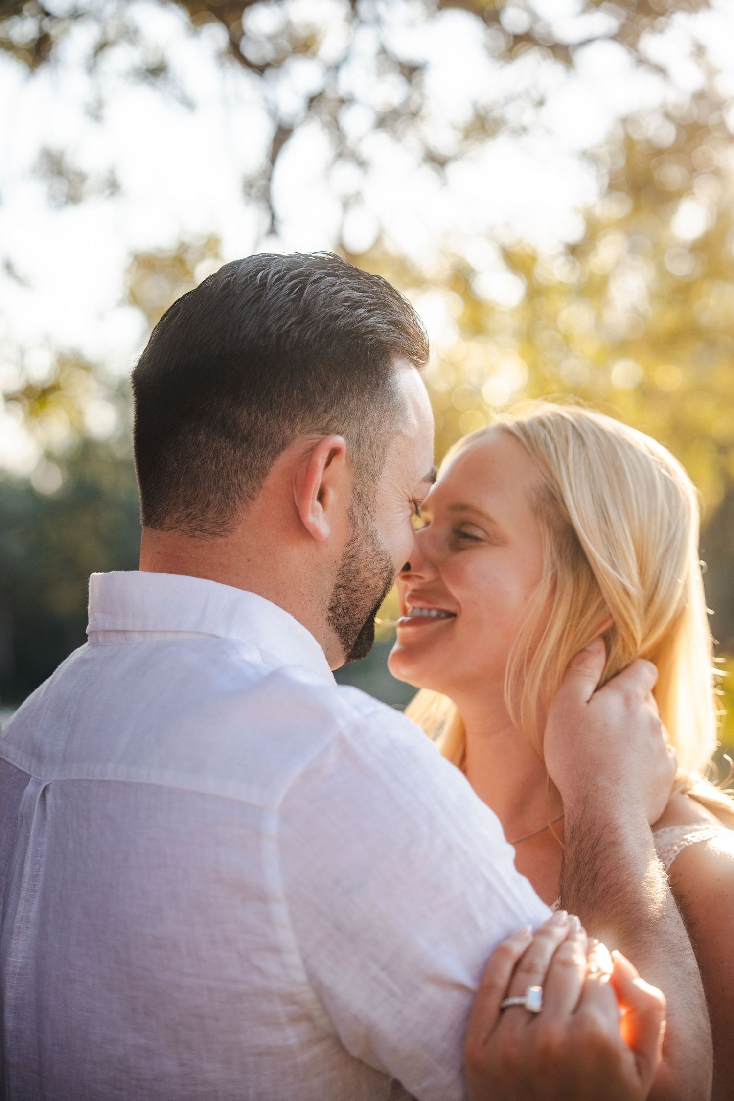 Intimate engagement portrait created through a guided session with couple sharing a soft moment at Tree Tops Park